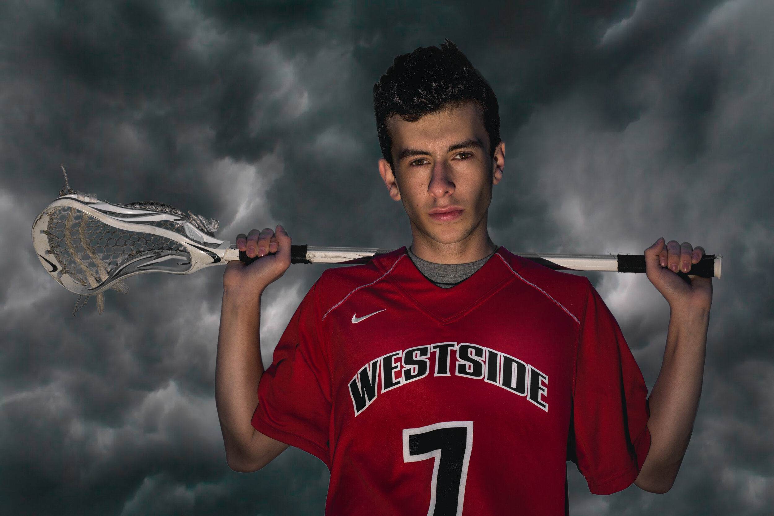 Westside highschool lacrosse player in front of thunderstorm clouds