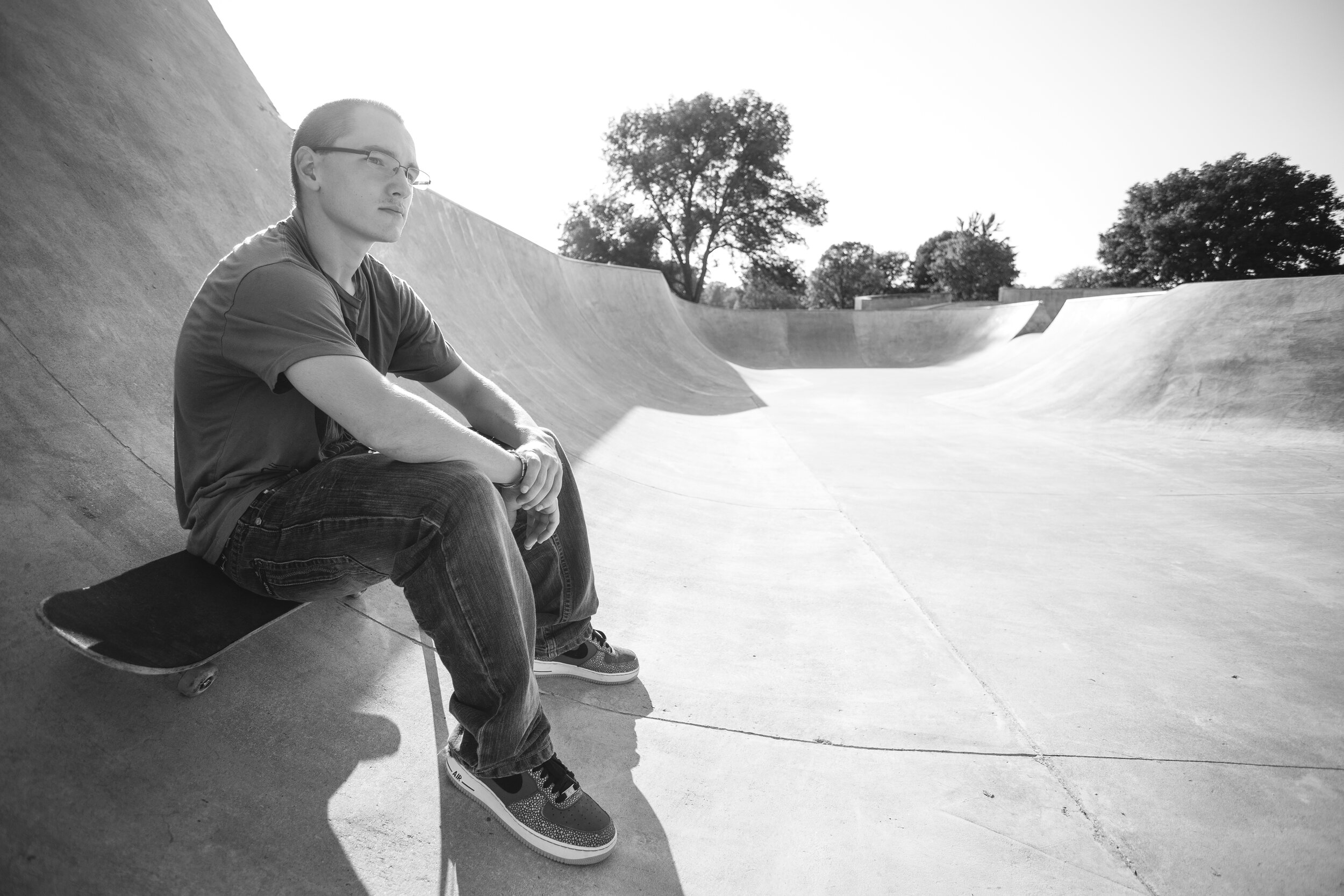 Omaha high school skateboarder sitting in skate park