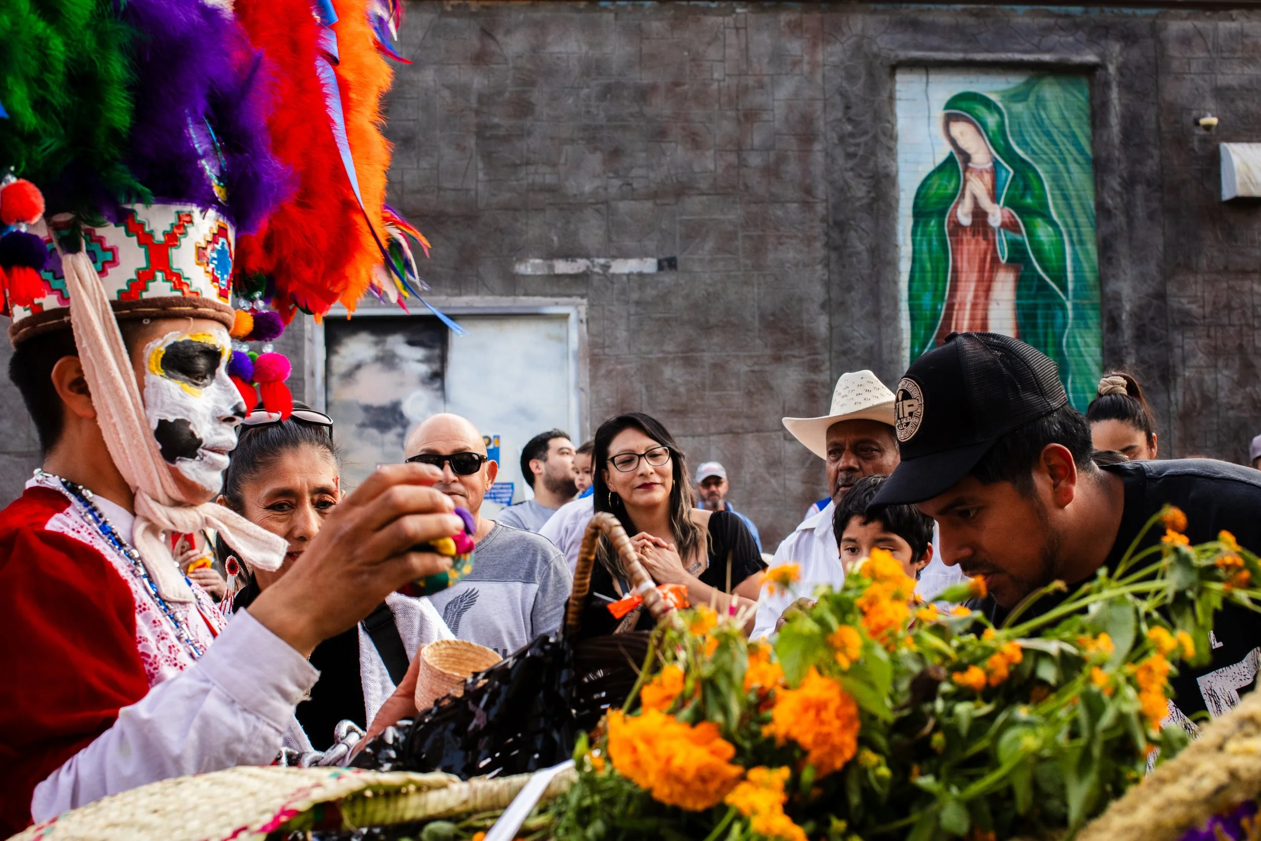  A boy dresses as El Catrín with marigolds while people gather for dia de los muertos in South Omaha. 