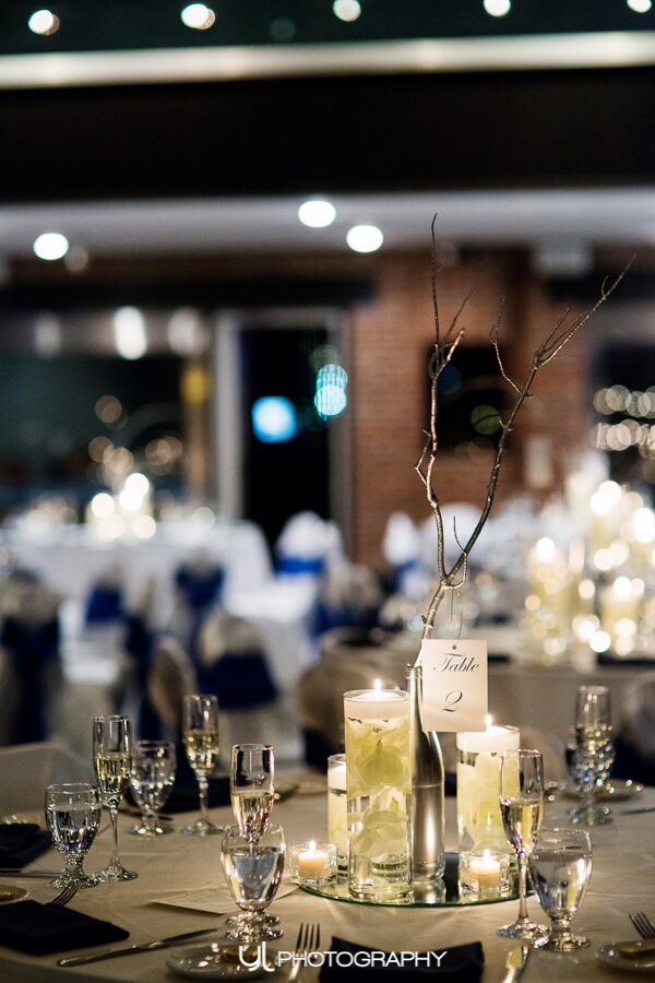 Centerpieces made out of spray painted San Pellegrino bottles and branches.