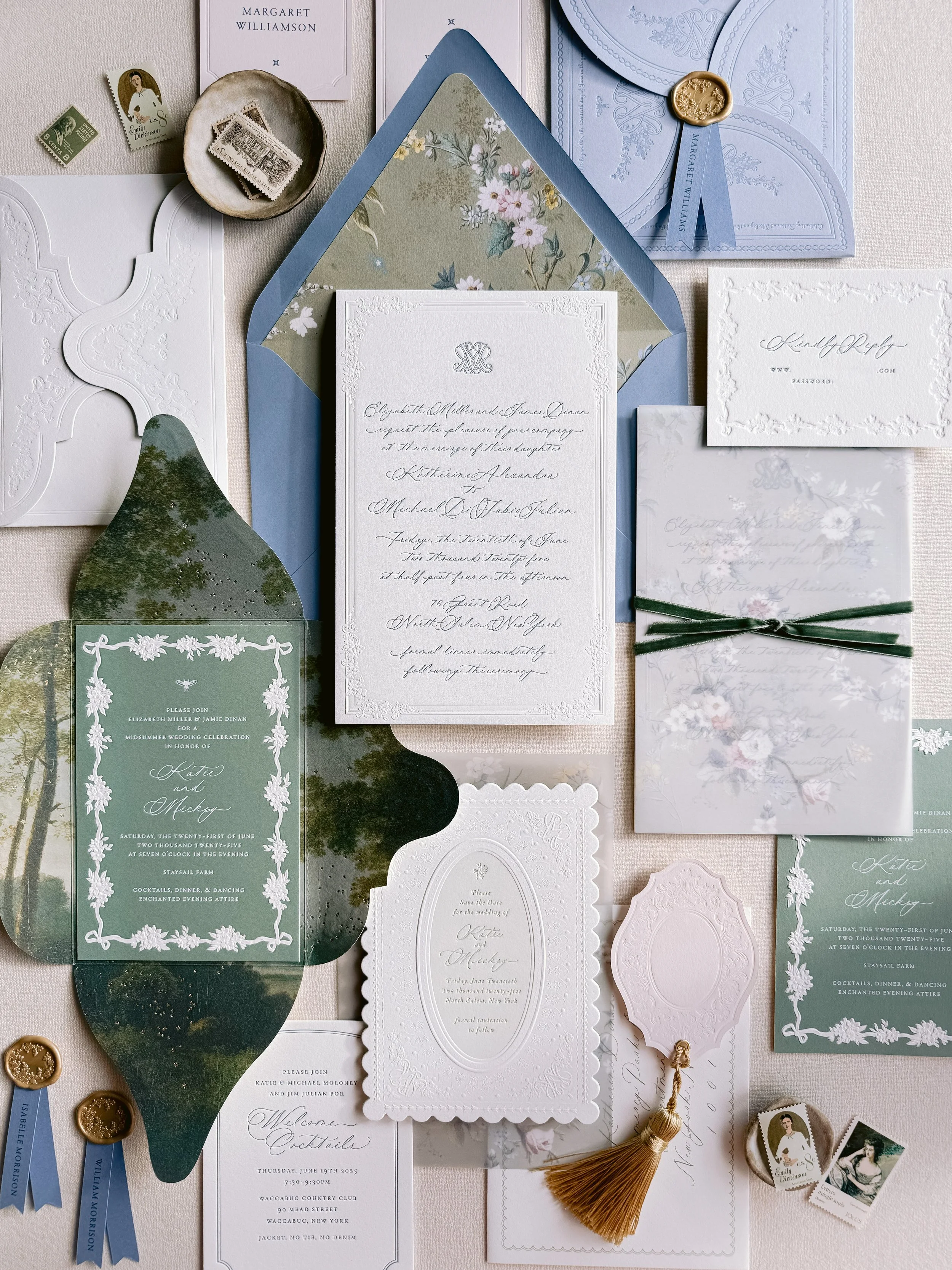 A collection of elegant wedding stationery, including invitation cards, envelopes, RSVP cards, and decorative tags, arranged on a flat surface.