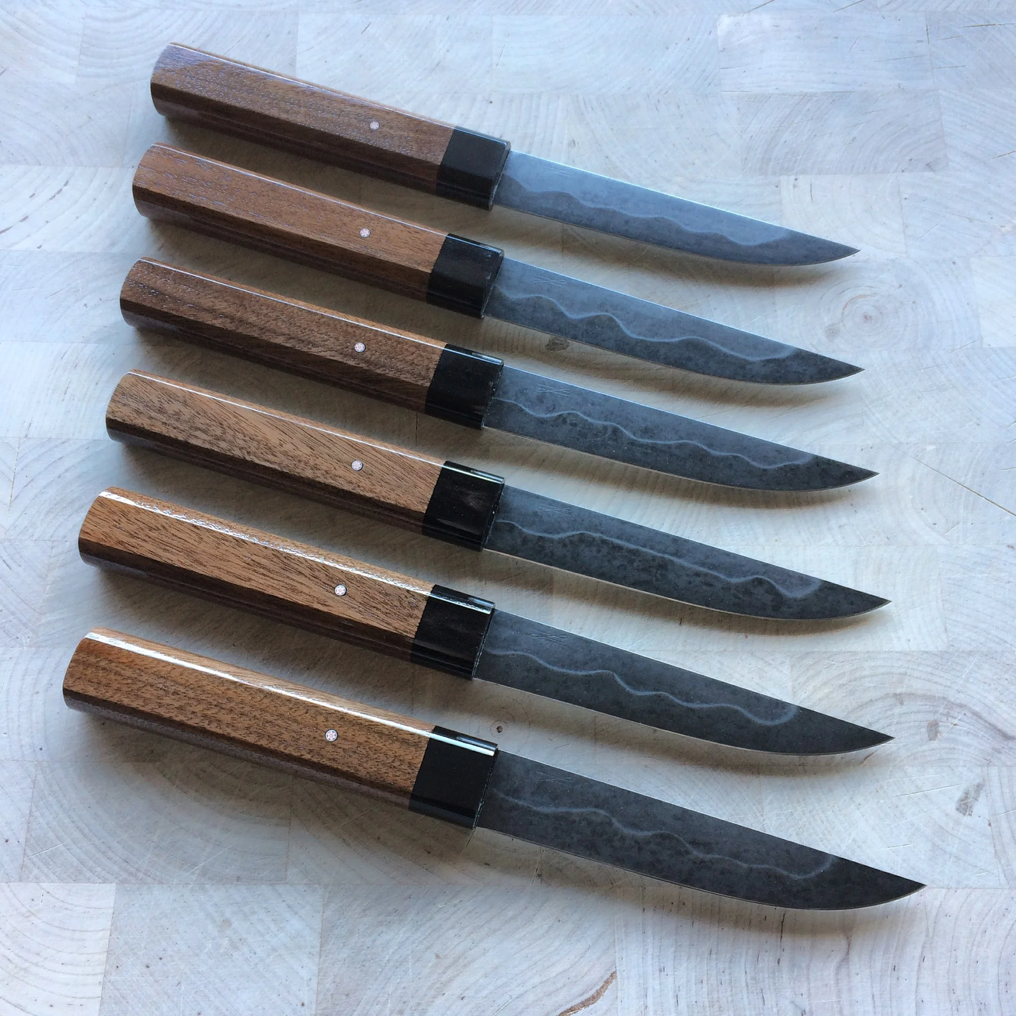 Steak Knife set of six. Blades are 1095, differentially heat treat with a dark forced patina. Handles are walnut and horn with small mosaic pins. 