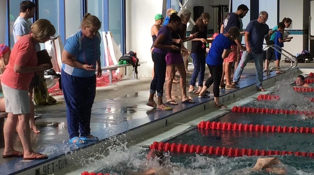 UVRay Sean Uiterwyk (far right) claims Fastest Man in the Pool honors with his 12.46 in the 25-meter freestyle. Volunteer timers are a huge part of every masters mini meet. 