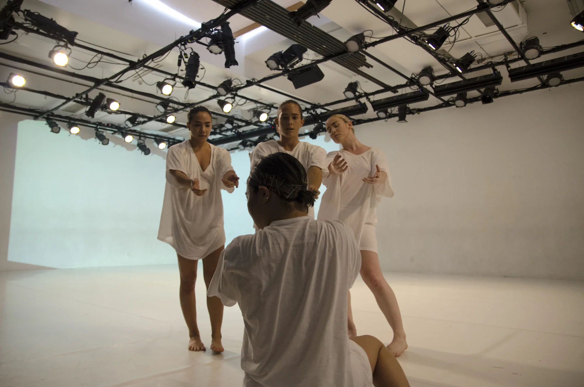 Three dancers hovered over one seated, photo by Umi Akiyoshi. Photo from DOC Series, October 2017.