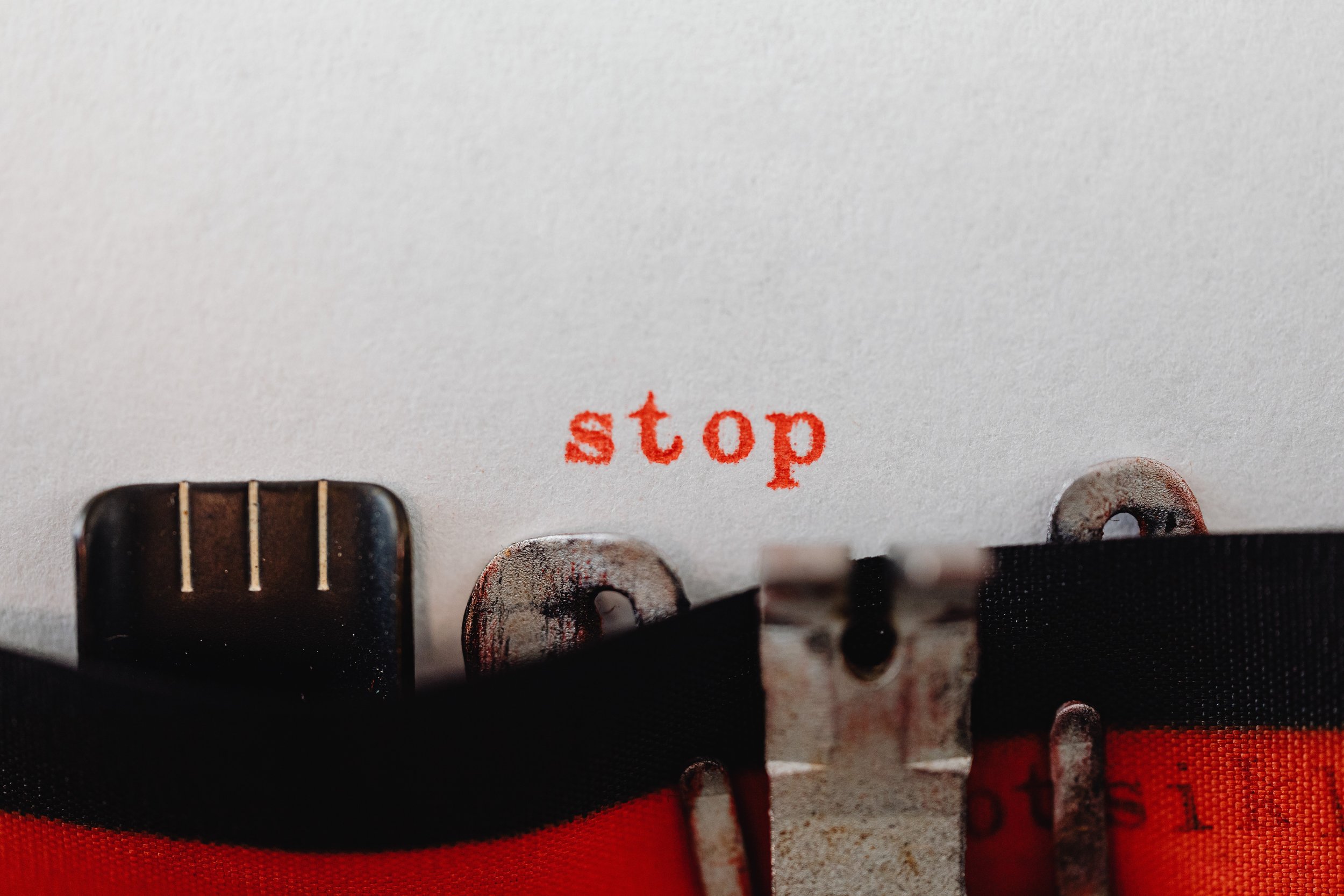 Typewriter text that says “stop” representing the meaning of assertiveness.