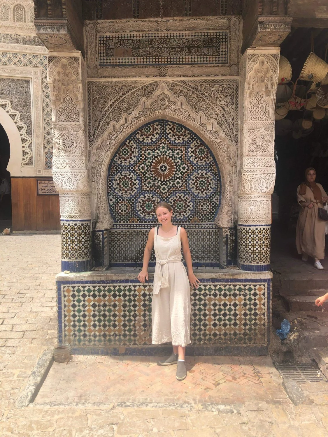 A picture of me with a fountain covered in tiles in Fes