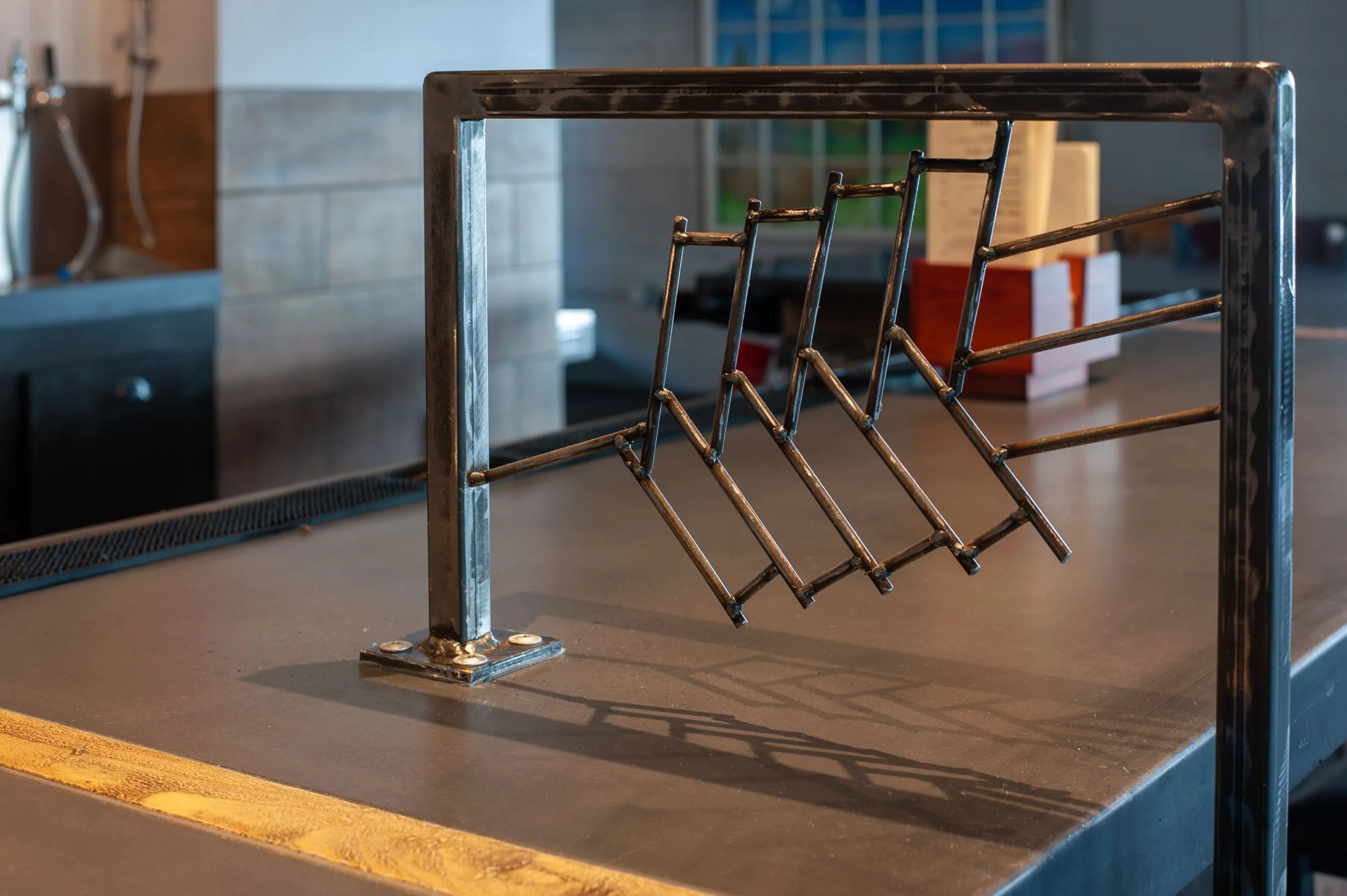 Custom designed and fabricated steel server station mirrors the breweries logo in the taproom