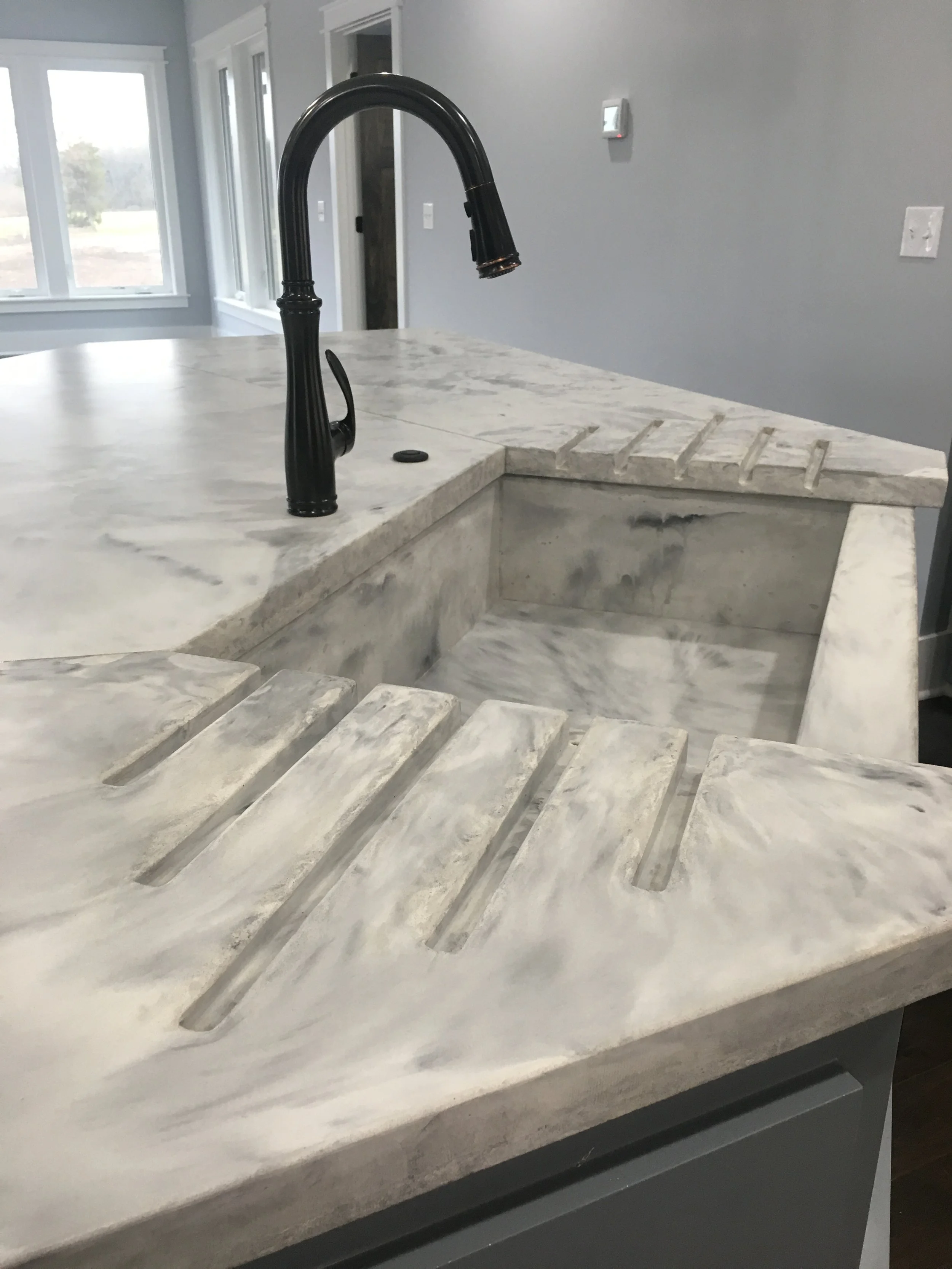 Italian Marble style concrete countertops with integrated farmhouse sink and drip trays