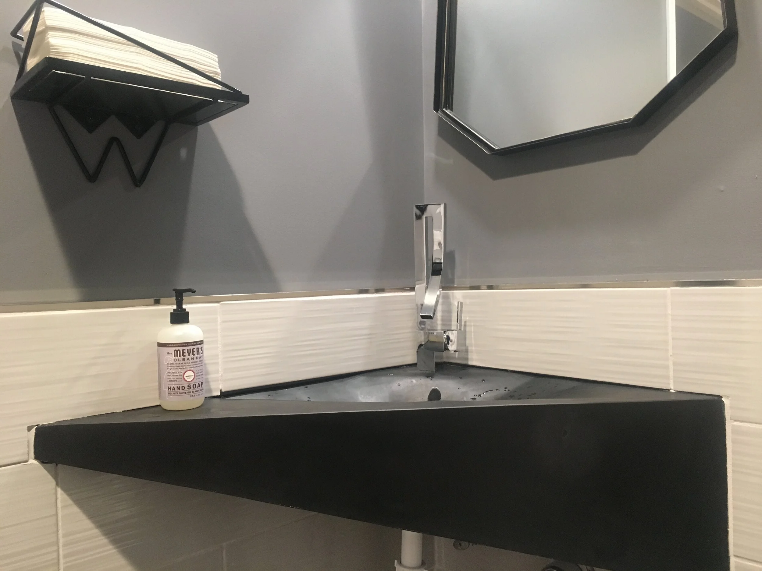 One of a kind fabric formed sink with geometric styling and the Windshift Brewing logo as the drain