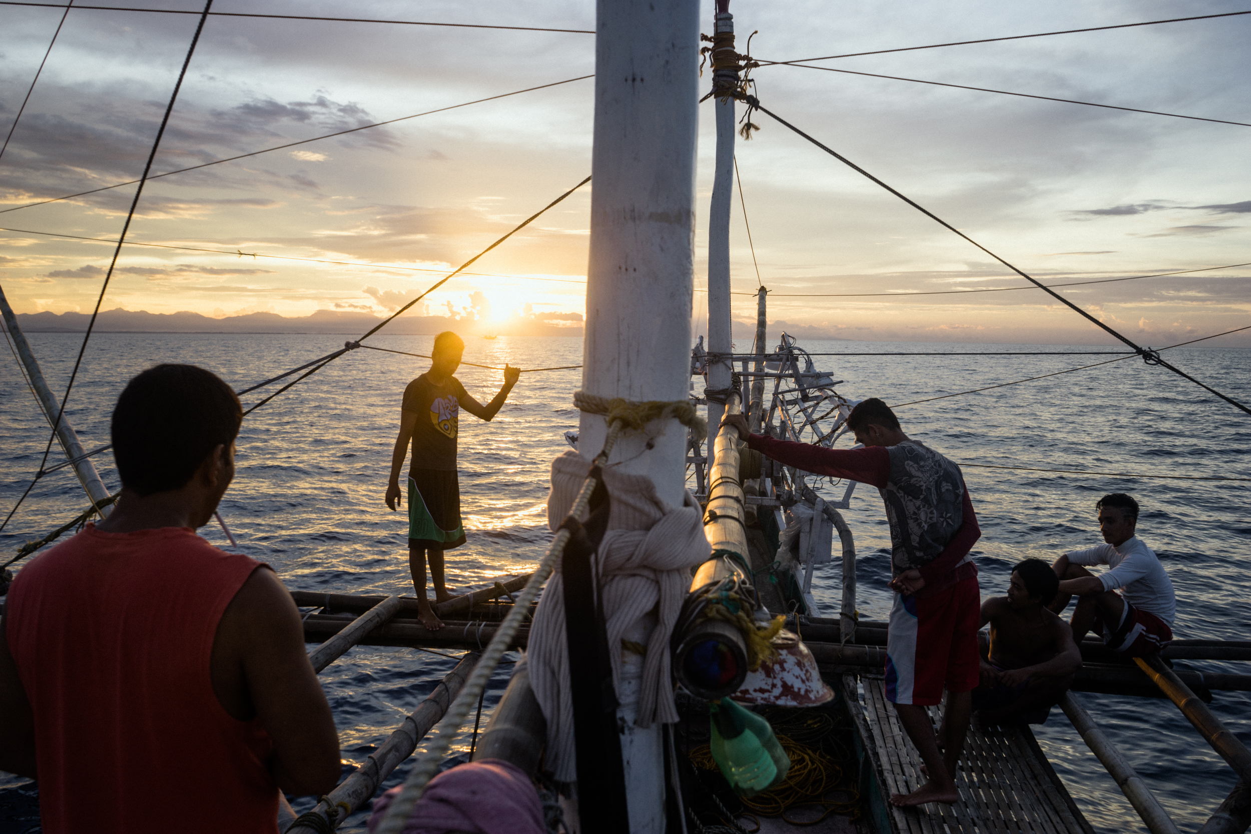 Kalibo, Philippines - September 21, 2015: The crew of a local fishing boat heads out for their night's catch. Members of the crew, who make approximately 35 USD per month, have expressed their desire to work on a larger fishing vessel for the promise of a higher income despite stories of fellow fishermen about the forms of abuse that happen on such vessels. Hannah Reyes