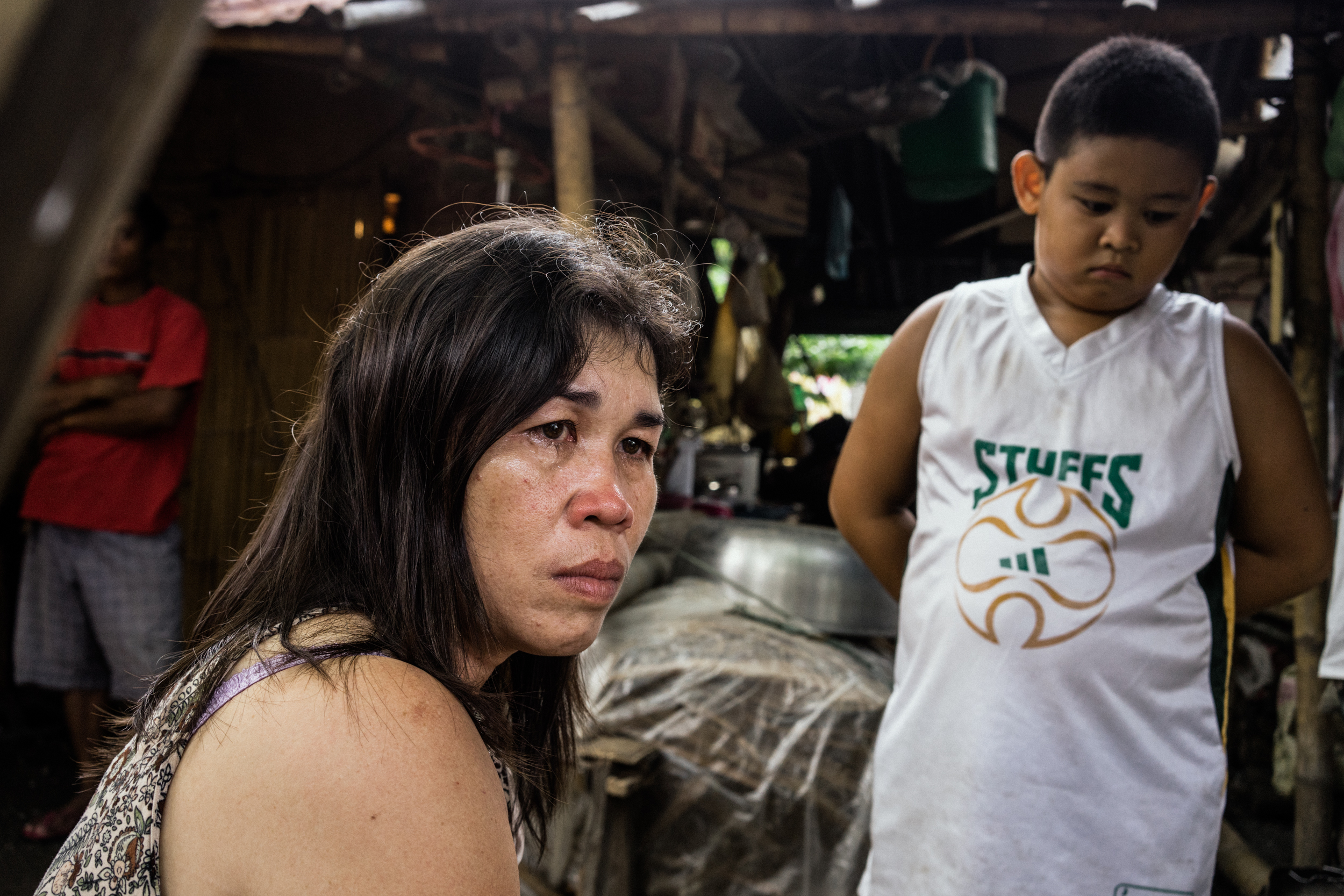 Kalibo, Philippines - September 20, 2015: Celia Robelo is seen with her son at a jail where she is being held on human trafficking and illegal recruitment charges following the death of a Filipino seafarer. Robelo claims that she did not have any knowledge of the illegal nature of her recruitment, claiming she only wanted to help these men find work and a way out of poverty. Hannah Reyes