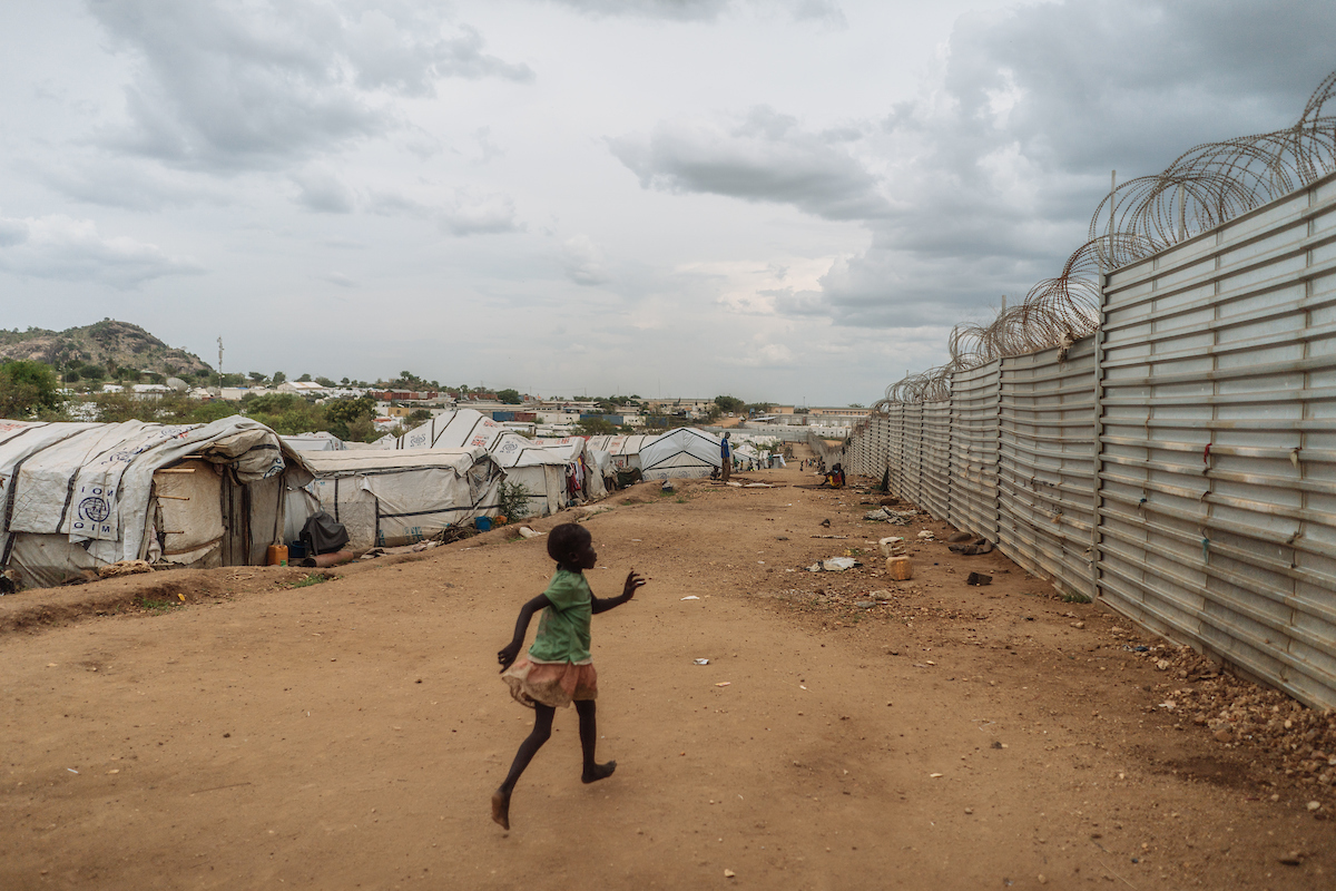 A young girl runs inside the protection of civilians site in Juba, South Sudan. In South Sudan, women and girls displaced from war must leave protection of civilians sites to collect firewood - a task traditionally done by women, who make up majority of the population in these camps. The journey is perilous and puts these women at continued risk of sexual violence, which rights groups have called an 'epidemic' in the country.