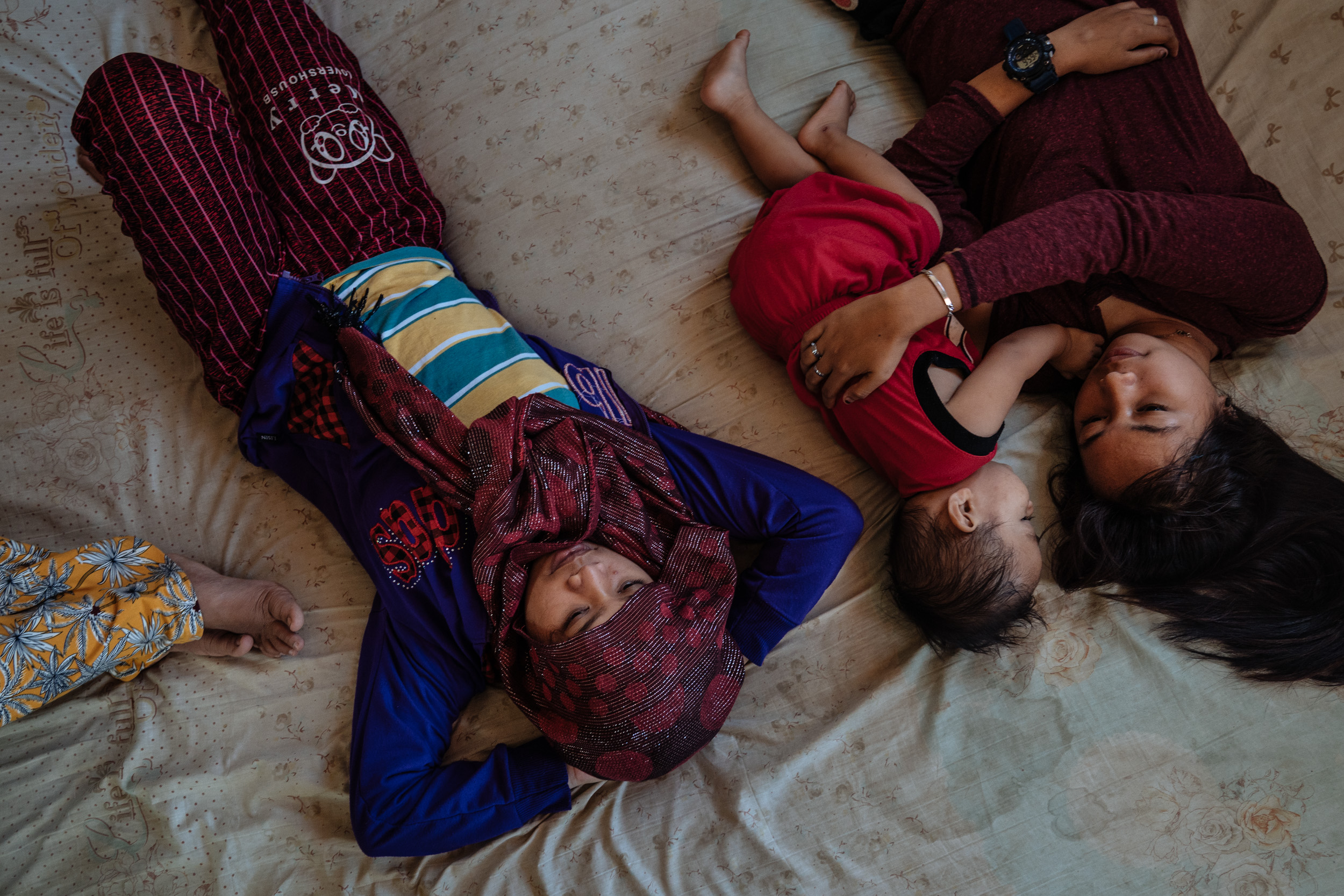  Noraima Lomondot (center) and Annah Manalundong (right) are seen in their house in a temporary housing shelter in Marawi City, outside the main battle area. The two babysit for their neighbors. Noraima sent her own child to another province, because