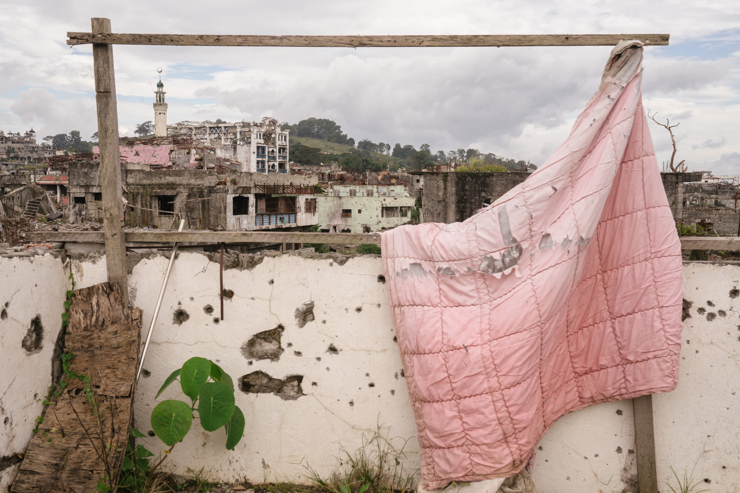  City ruins are seen through a rooftop in the battle area in Marawi City. It has been more than a year since the Philippine military declared the Muslim-majority city of Marawi “liberated” from ISIS-linked militants. But the ravaged city is still wai