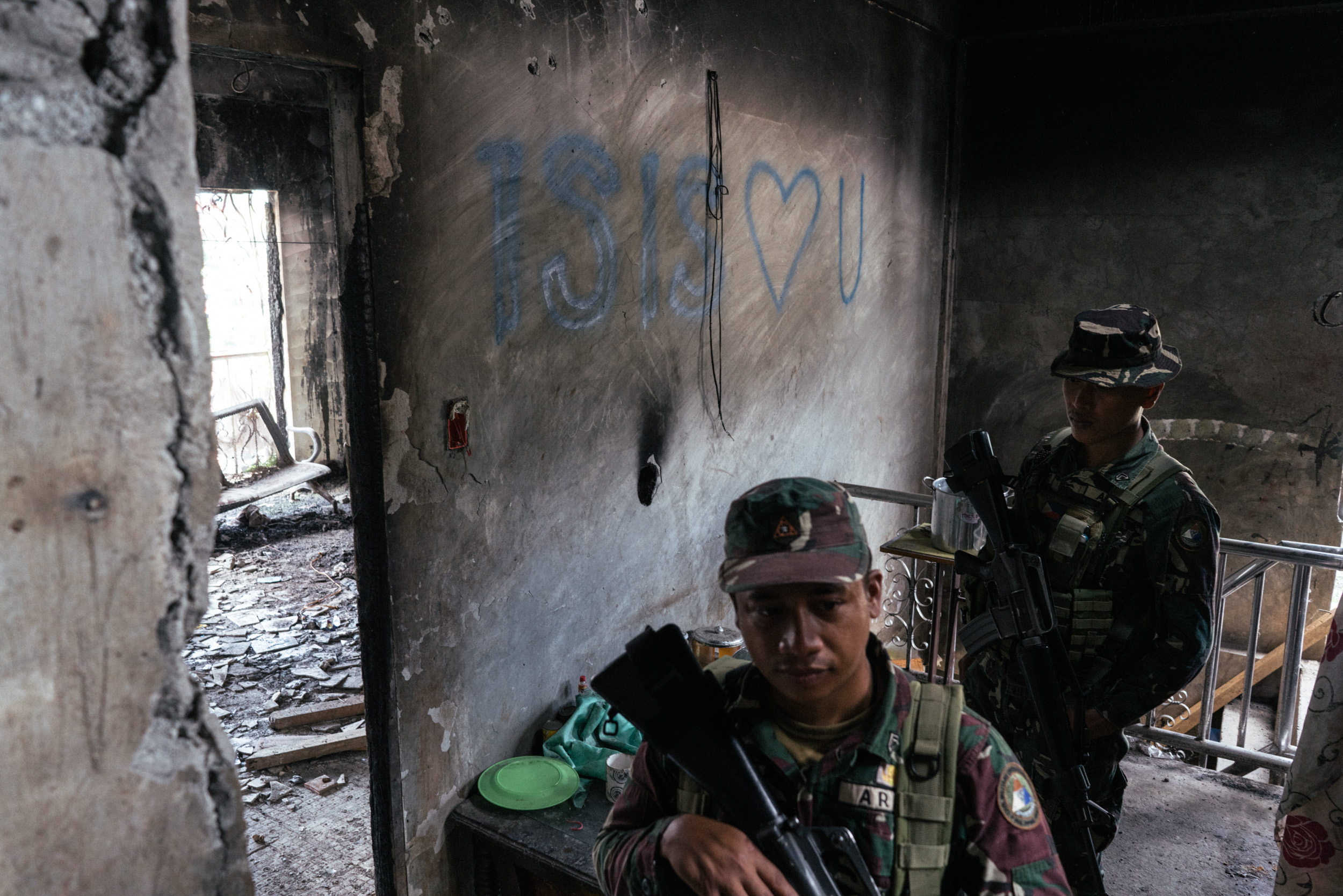  Filipino soldiers are seen by a wall with the graffiti 'ISIS ❤ U' in Marawi, Philippines on November 15, 2017. Marawi City is in ruins after Islamic State (IS) inspired militants laid siege to the city in a battle that lasted for five months, displa