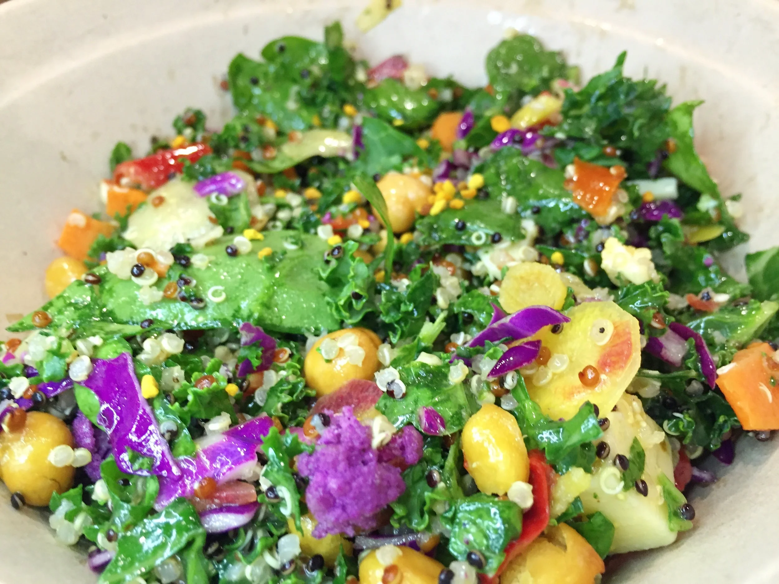 Beekeeper's Quinoa Bowl&nbsp;| Tri-colored quinoa, aged Tillamook cheddar, roasted chickpeas, Mama Lil's spicy peppers, rainbow cauliflower, kale, broccoleaf, purple cabbage. Tossed in Wildflower Honey Dijon dressing and topped with bee pollen.