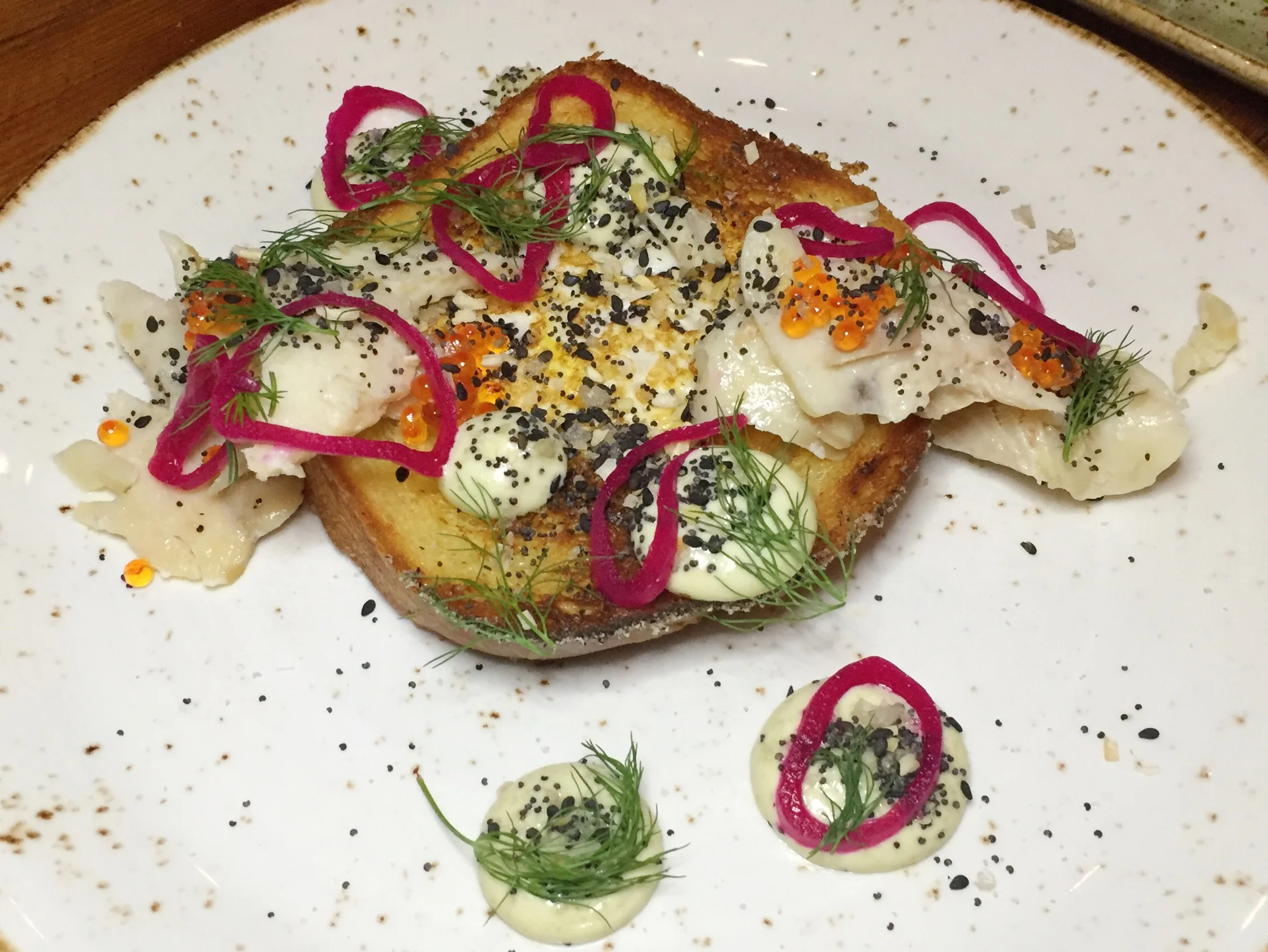 Toad in a Hole&nbsp;| House-smoked trout, caper aioli, shallot, everything spice.