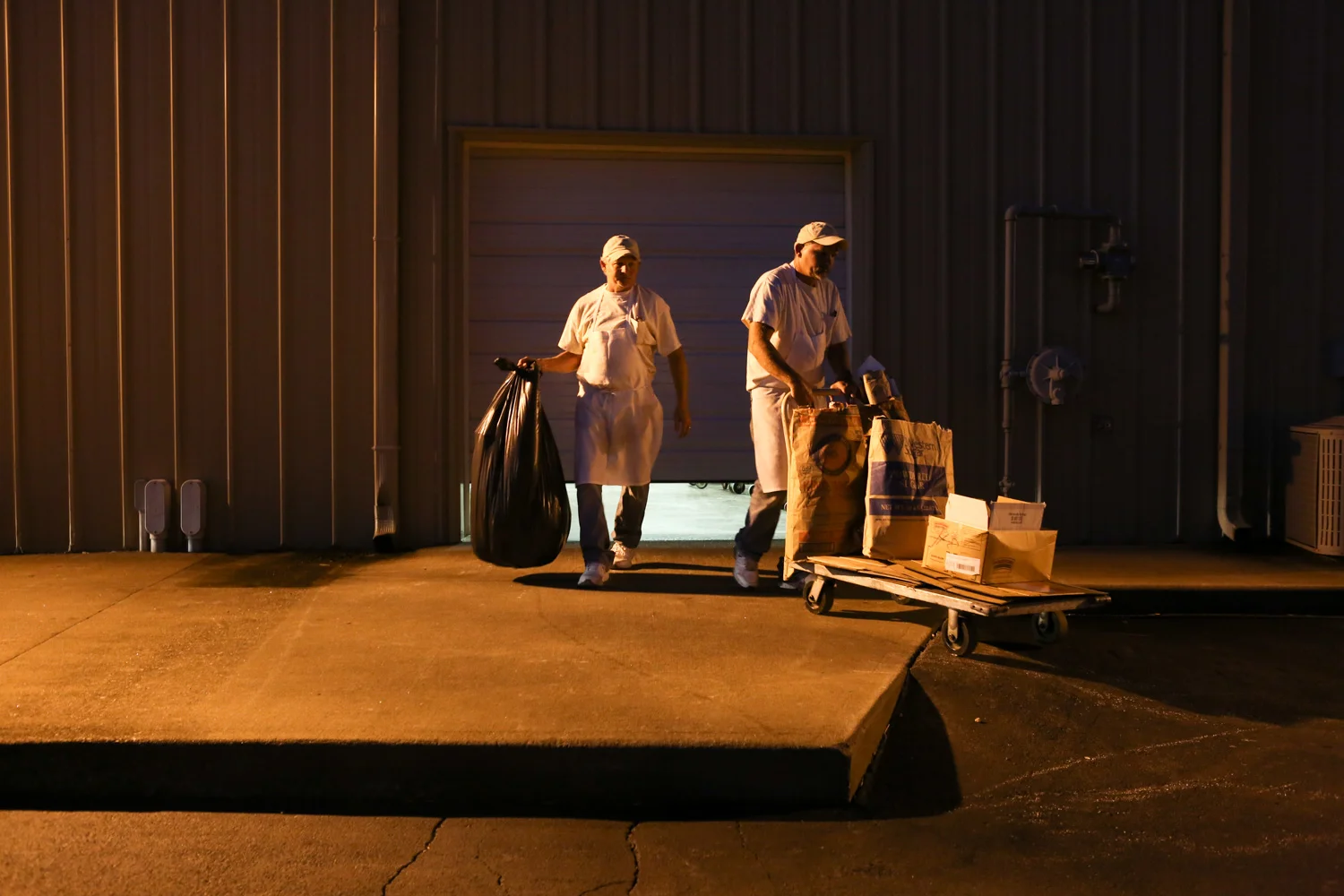 Joe (right) and Paul (left) take out garbage that was generated from one night of baking. The brothers normally work night shift from 11PM to 7AM, sometimes longer on weekends.