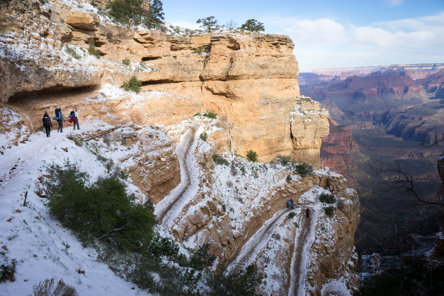With a fresh coat of snow on the ground in Arizona, several hikers being the trek from the South Rim of the Grand Canyon along the South Kaibab Trail.