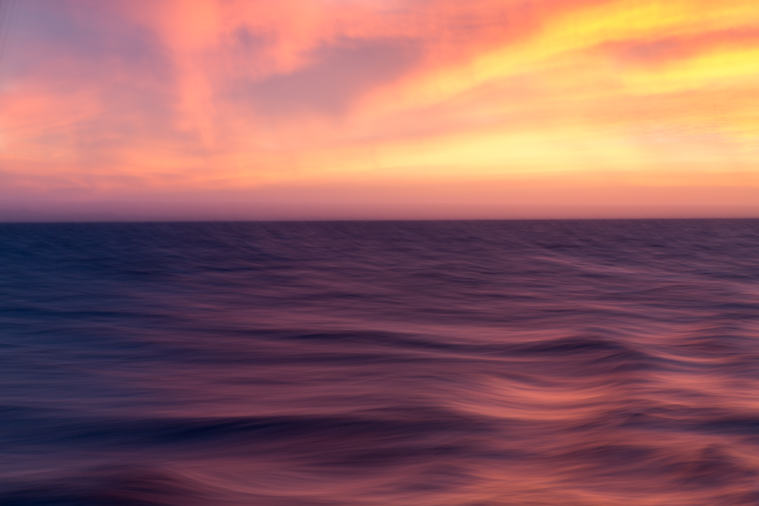In the waters near Isla Coiba National Park, the sunrise illuminates the clouds, sky and waters in brilliant and vibrant colors.