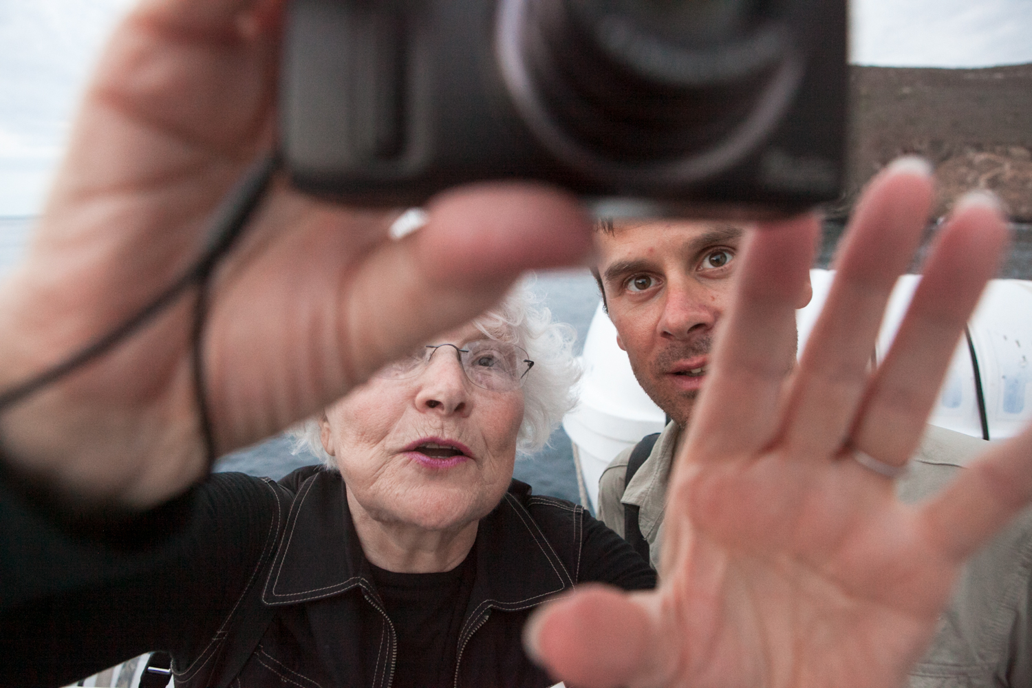 On an expedition vessel in the Galapagos Islands, two passengers view images on the back of a camera.