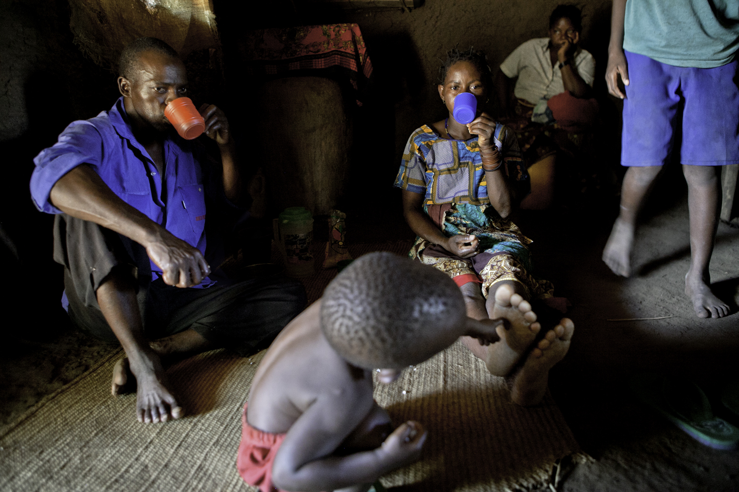 Well water is fresh, clean and healthy, and it acts as the main drinking fluid for local residents. While sitting on the floor, Mom and Dad wash down lunch with cups of water.