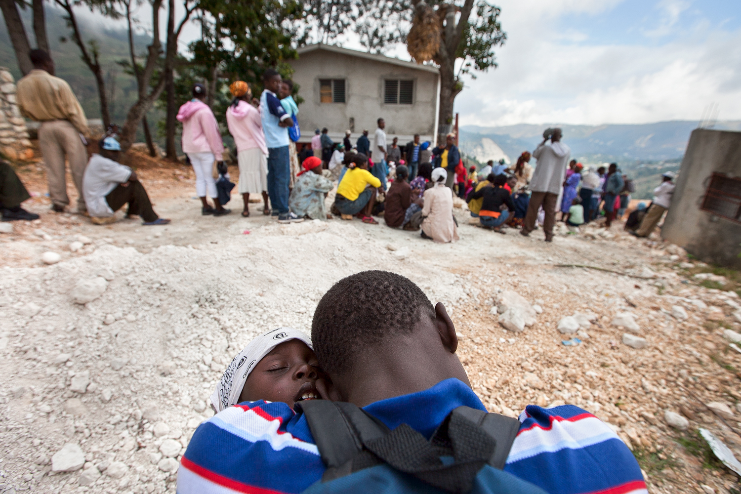  Two boys sleep on one another as they await their turn with a nurse at Gramothe's medical clinic. The teen carried his younger sibling for hours on foot to seek treatment. Medical teams from outside Haiti provide care to villagers several times a ye