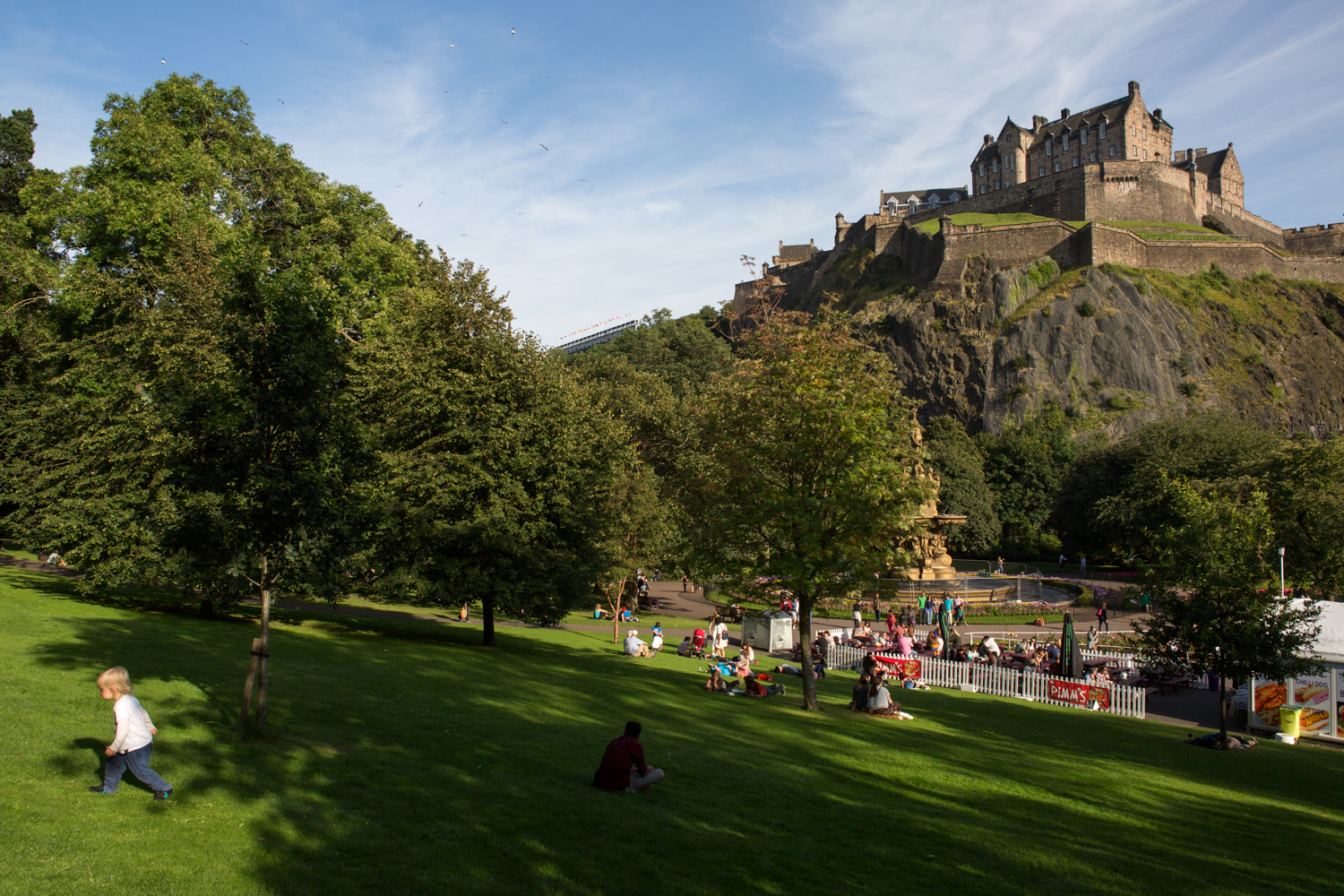  Scotland's Edinburgh Castle acts as a backdrop to the city's Princes Street Gardens. A young child walks up the hill. 