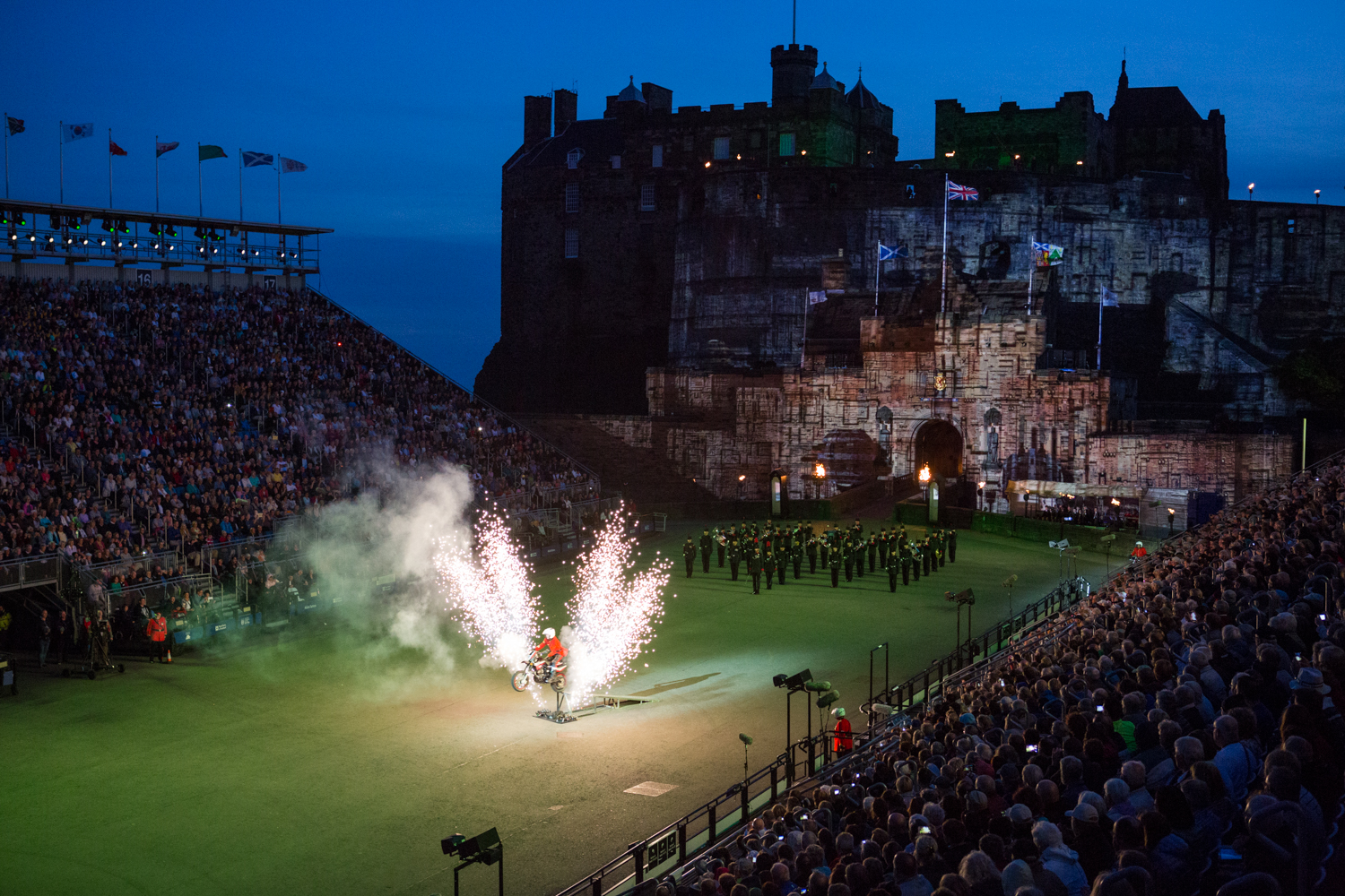  During the annual Military Tattoo in Edinburgh, Scotland, a motorcycle stunt driver takes off amongst fireworks. The performance is held for about three weeks with the Edinburgh Castle as a backdrop. 