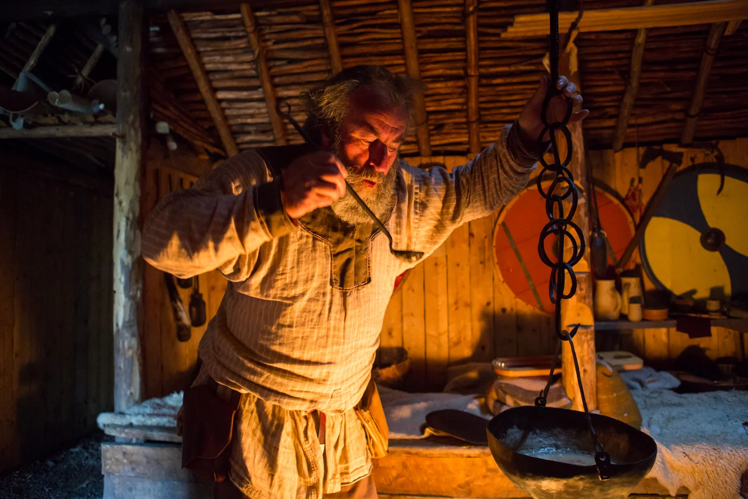 An interpretor, dressed in period costume, stands inside a renovated building at L'Anse aux Meadows and tastes a soup. Named a UNESCO World Heritage Site, the location is where Lief Erikson founded North America.