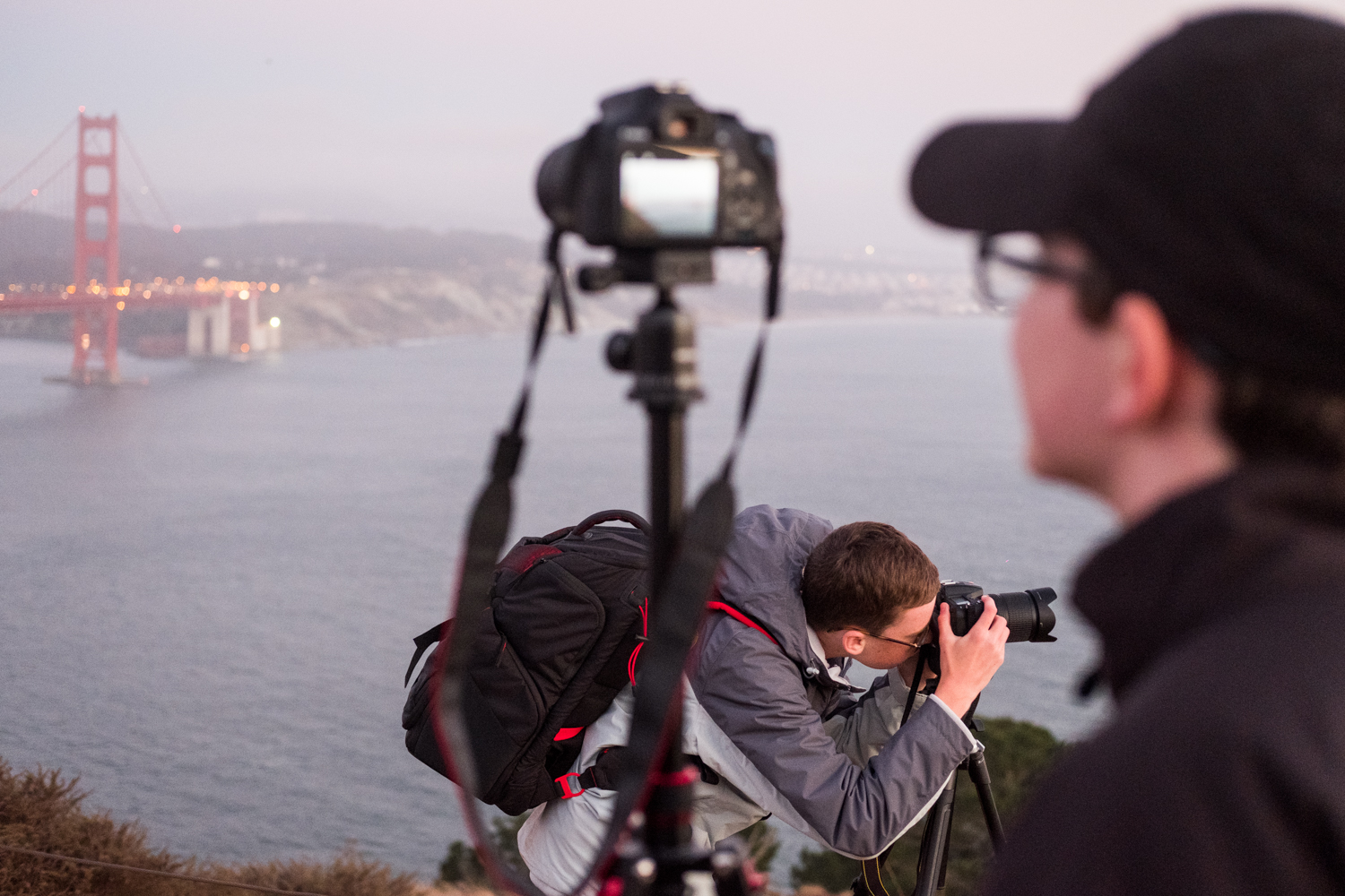  At dusk, two students photograph at The Golden Gate Bridge Vista Point. 