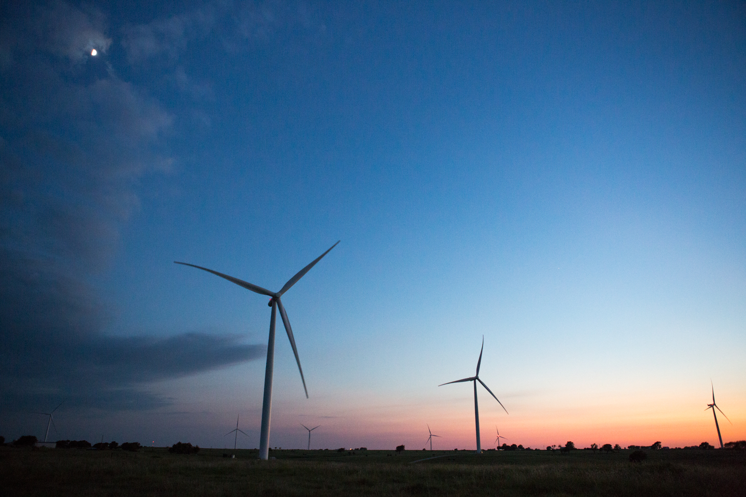  At dusk under moonlight, several wind turbines fill the landscape at Tyler Bluff Wind Facility in Muenster, Texas. 