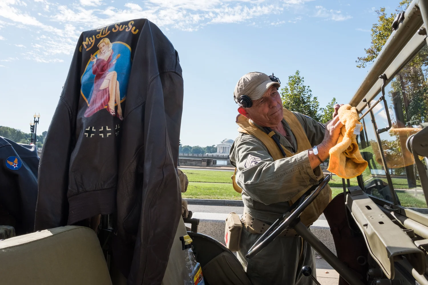 Joe Becker, a war re-enactor with the Allied Airmen's Preservation Society, cleans the Willy Jeep windshield near the World War II Memorial in Washington, D.C. during an Honor Flight event. Honor Flight is when veterans from around America visit the memorials on The National Mall.