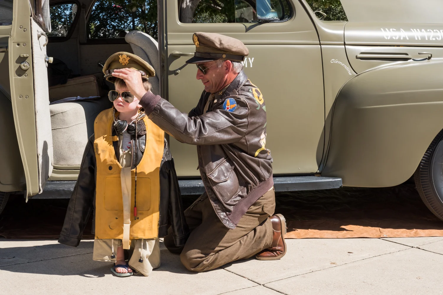 Chris Gabers, a war re-enactor with the Allied Airmen's Preservation Society, dresses Kenneth Blasi in Army attire near the World War II Memorial in Washington, D.C. during an Honor Flight event. Honor Flight is when veterans from around America visit the memorials on The National Mall. Kenneth's grandfather, C Patrick McCourt, is a veteran and part of the U.S. Park Service "Living History."