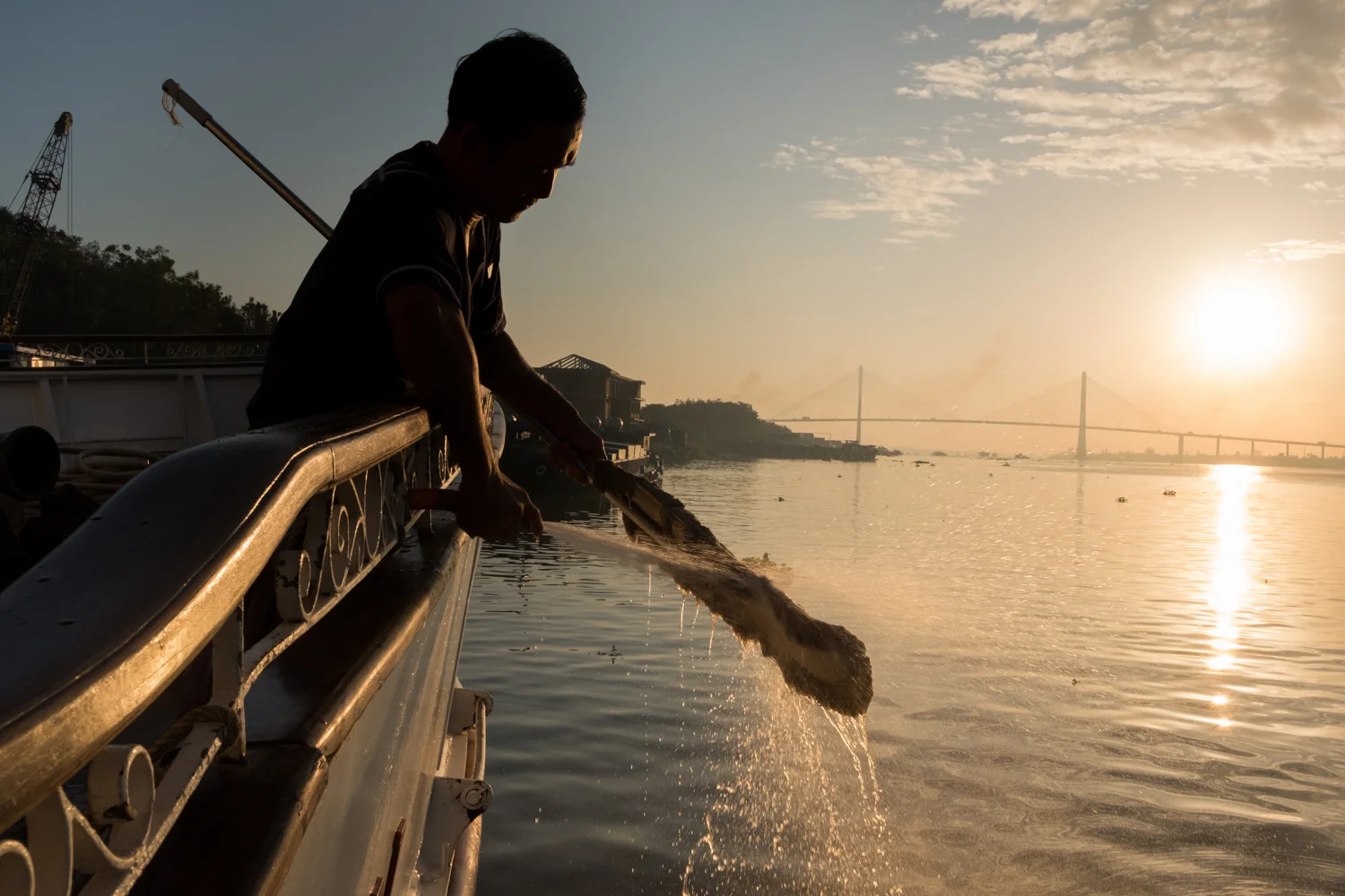 A crewman aboard The Jahan cleans his mop at a dock in My Tho, Vietnam.