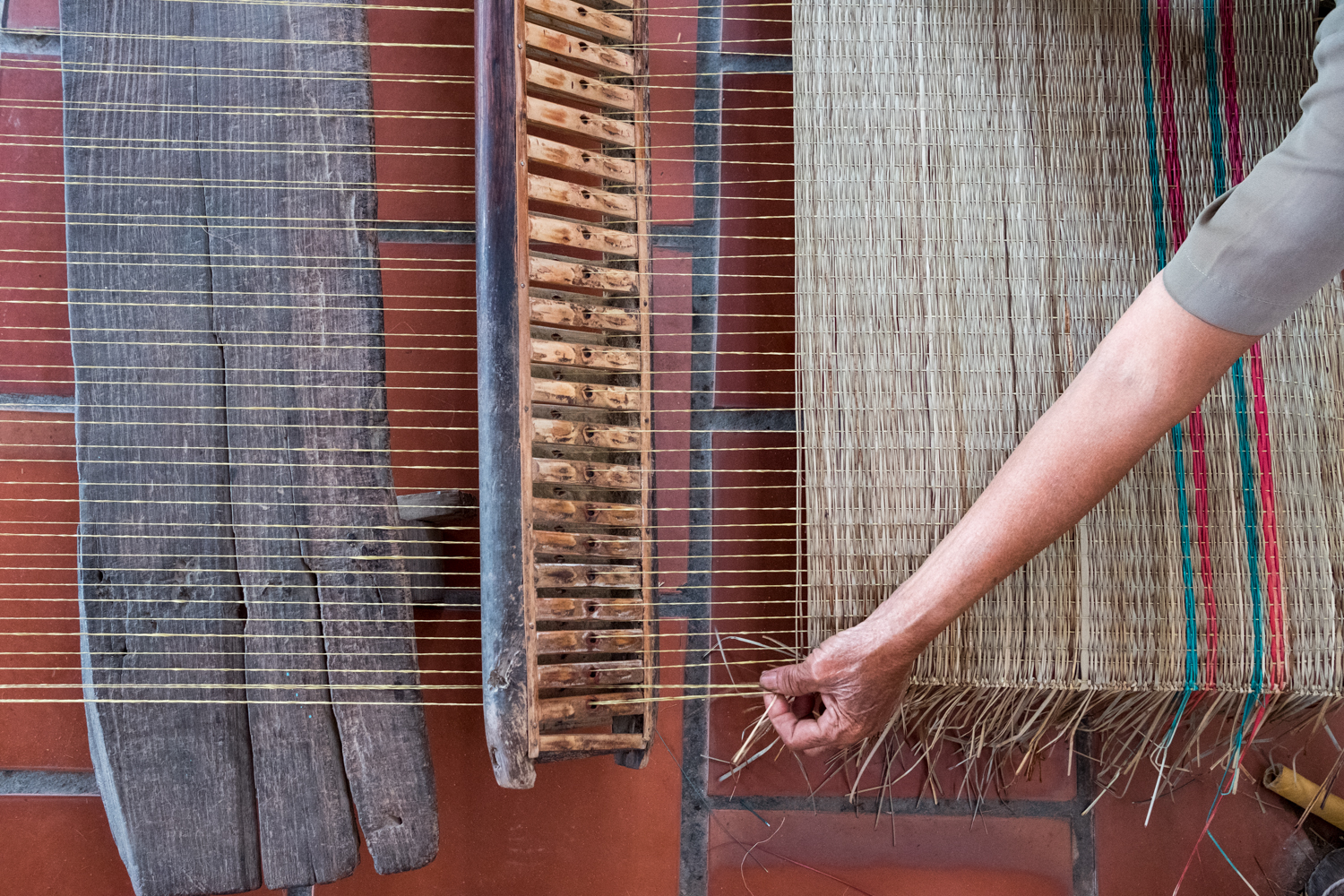  On Binh Thanh Island, a local woman works on a rattan mat. 