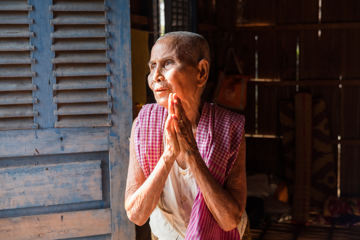  A local Cambodian woman in the village of Angkor Ban pauses for a moment of reflection in her home's doorway. 