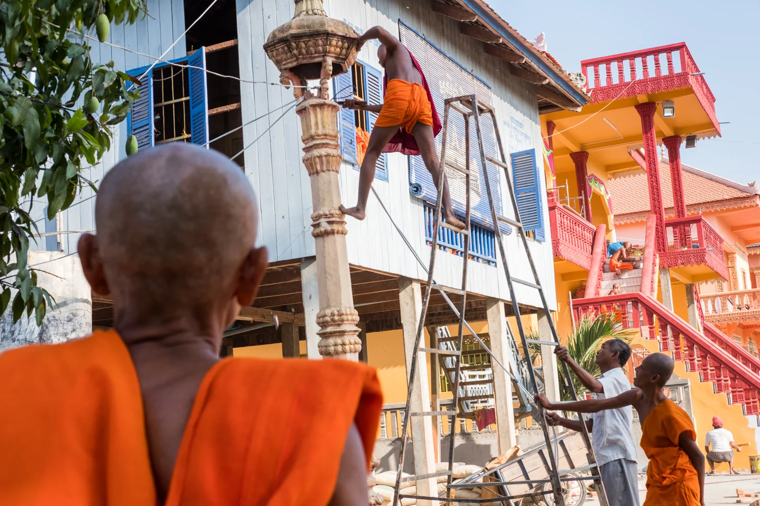 A group of monks perform construction activities outside their temple in Angkor Ban, Cambodia.