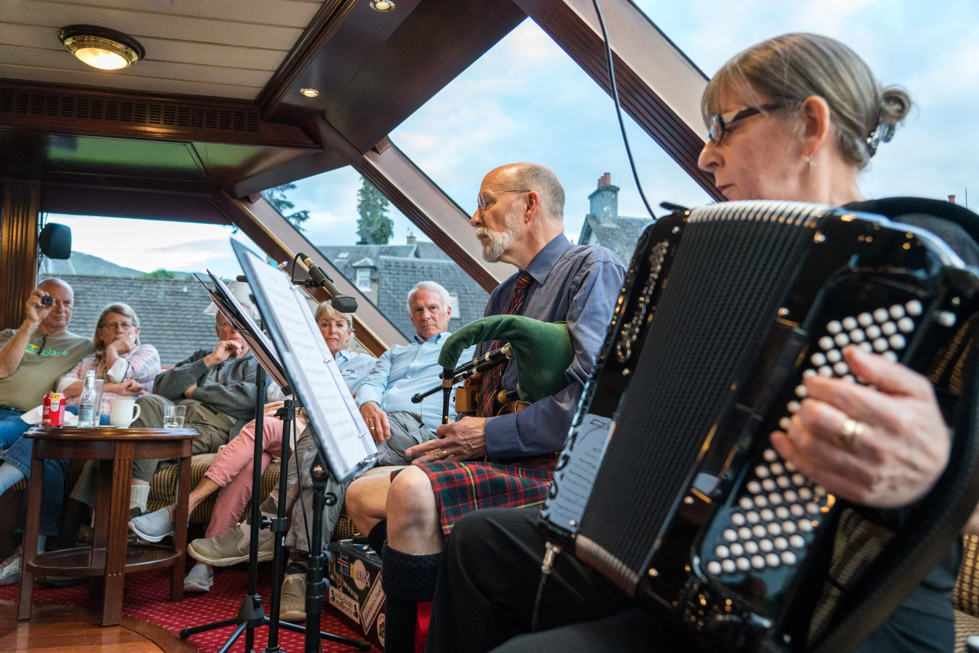 Aboard Lord of the Glens at Fort Augustus, Scotland, local musicians entertain guests with traditional instruments.