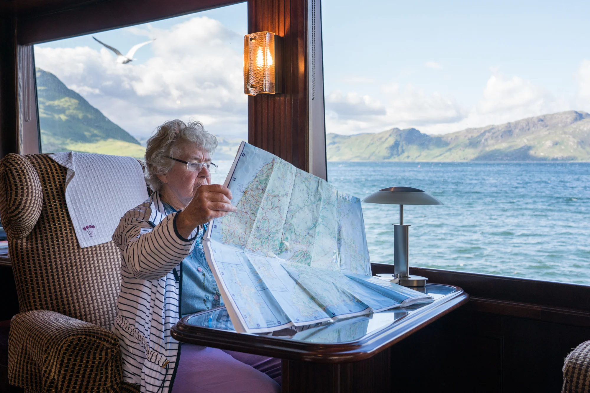 Outside Armadale, Scotland, a guest studies a map aboard Lord of the Glens.