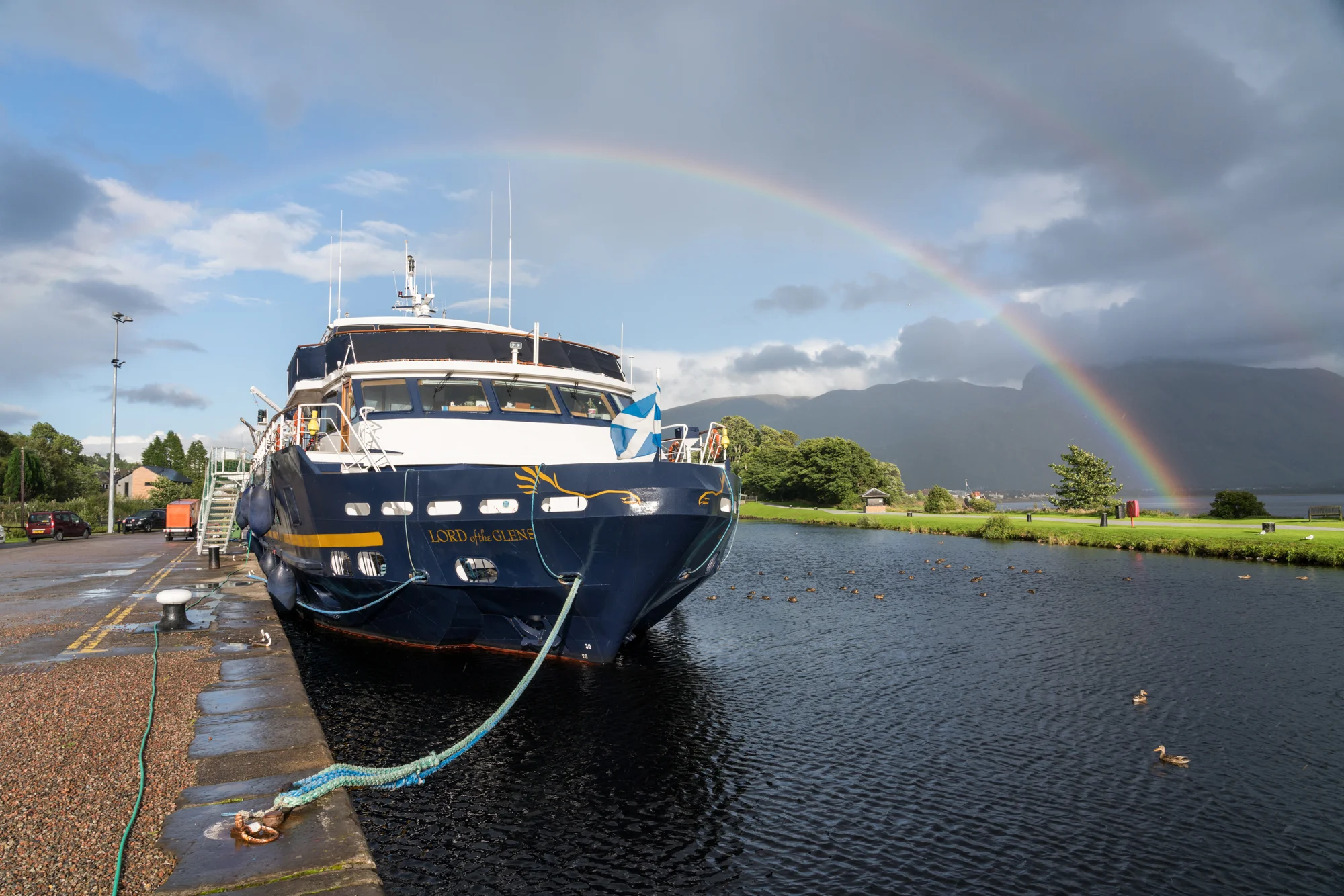 While docked in Corpach, Scotland, along the Caledonian Canal, a rainbow spans the landscape.