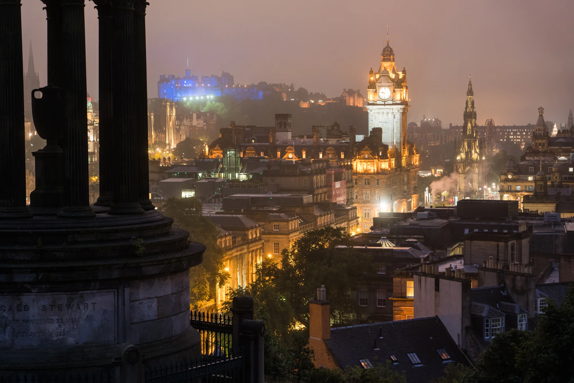 The Balmoral Hotel’s tower and The Edinburgh Castle are illuminated at dusk as seen from Calton Hill.