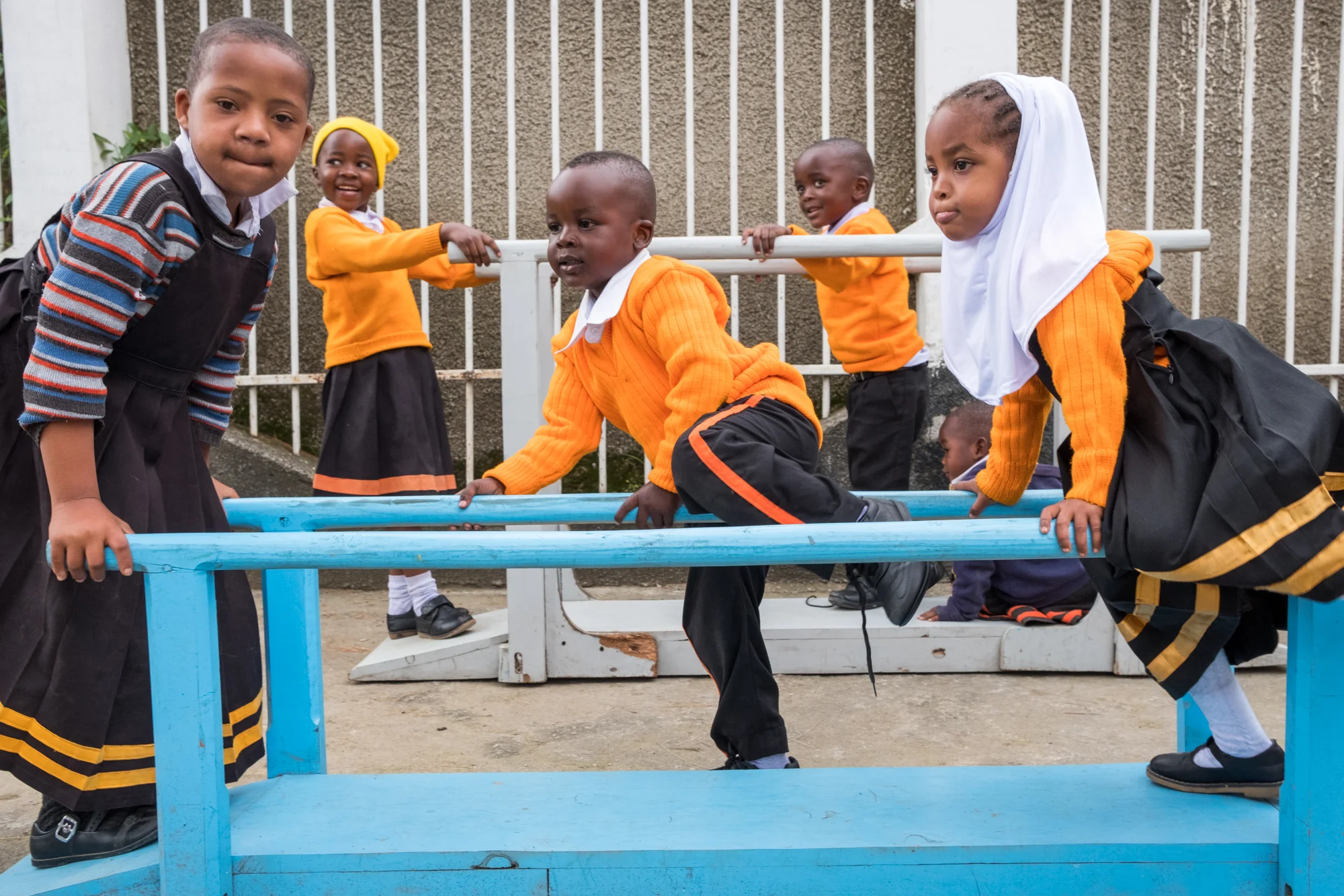Students at Child Support Tanzania interact and play on assisted walking equipment.