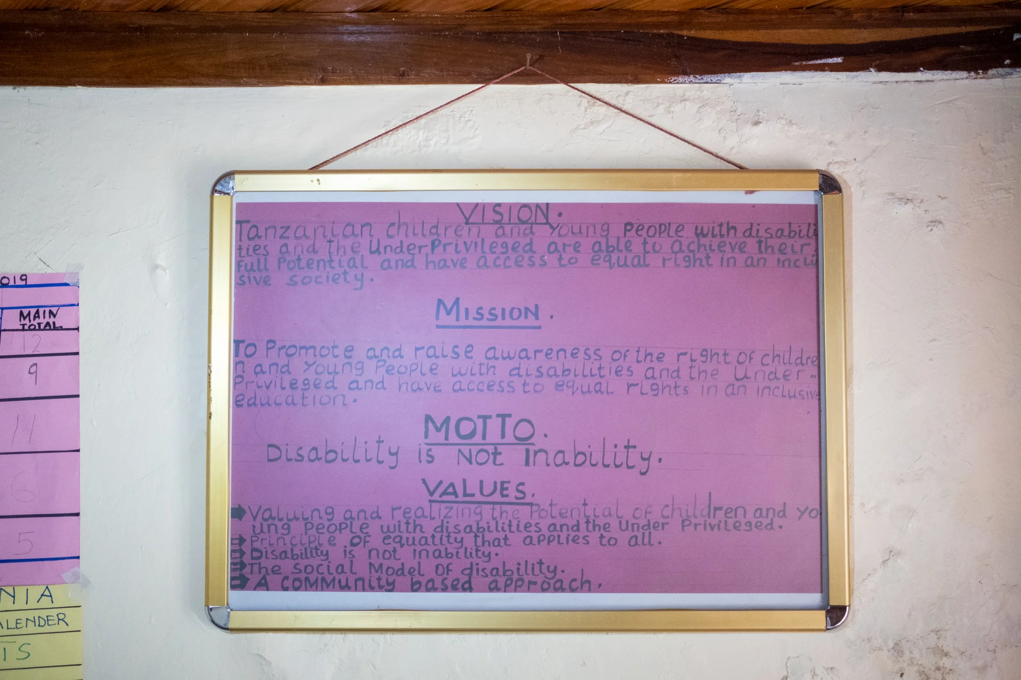 At Child Support Tanzania, a non-governmental organization located in Mbeya, Tanzania, that educates disabled children, a motto sign hangs on the wall in the teacher’s office.