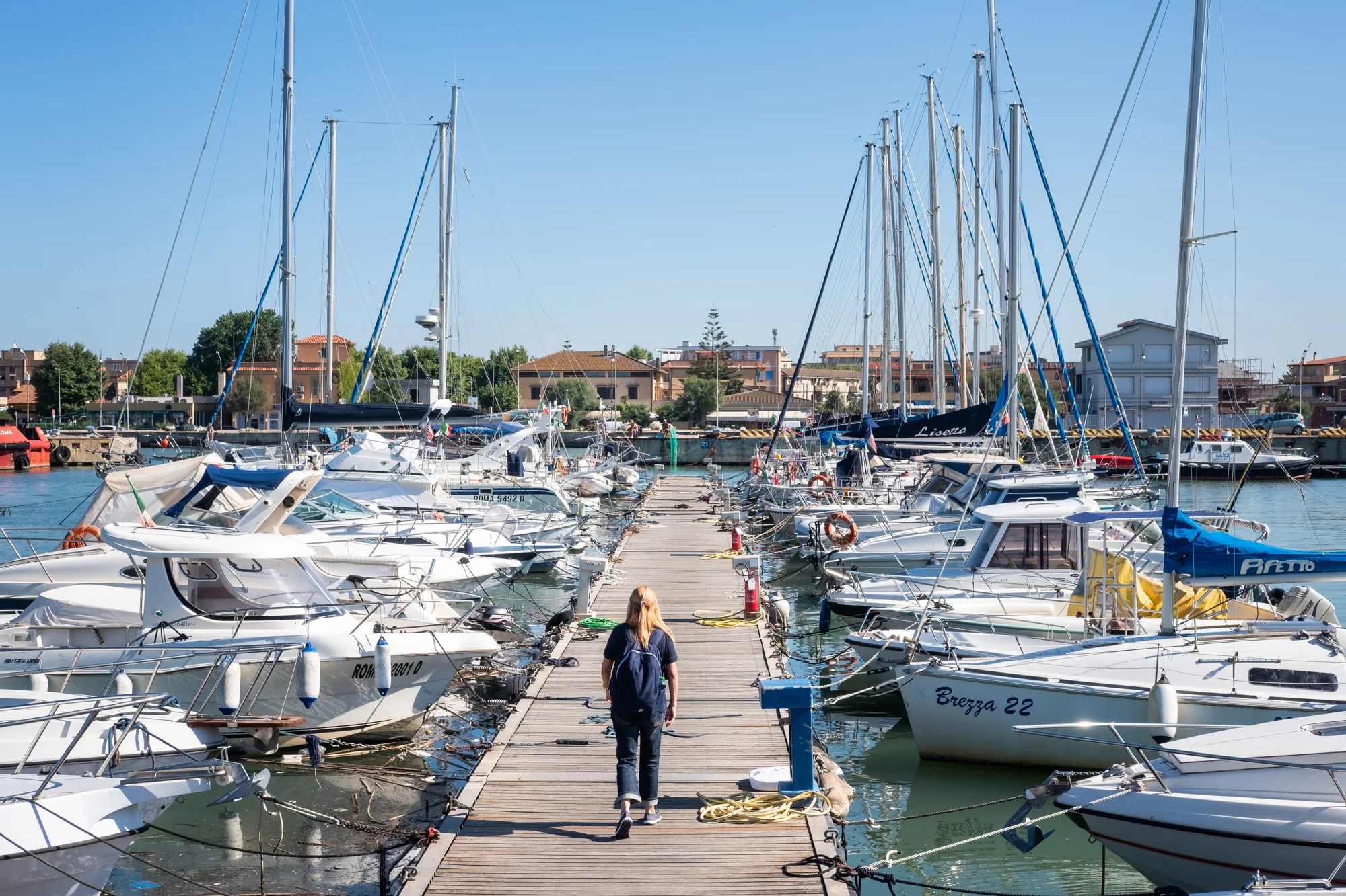 Patrizia Pilloni walks along a Fiumicino Harbor pier in Italy to meet her instructor for a daily sailing lesson.