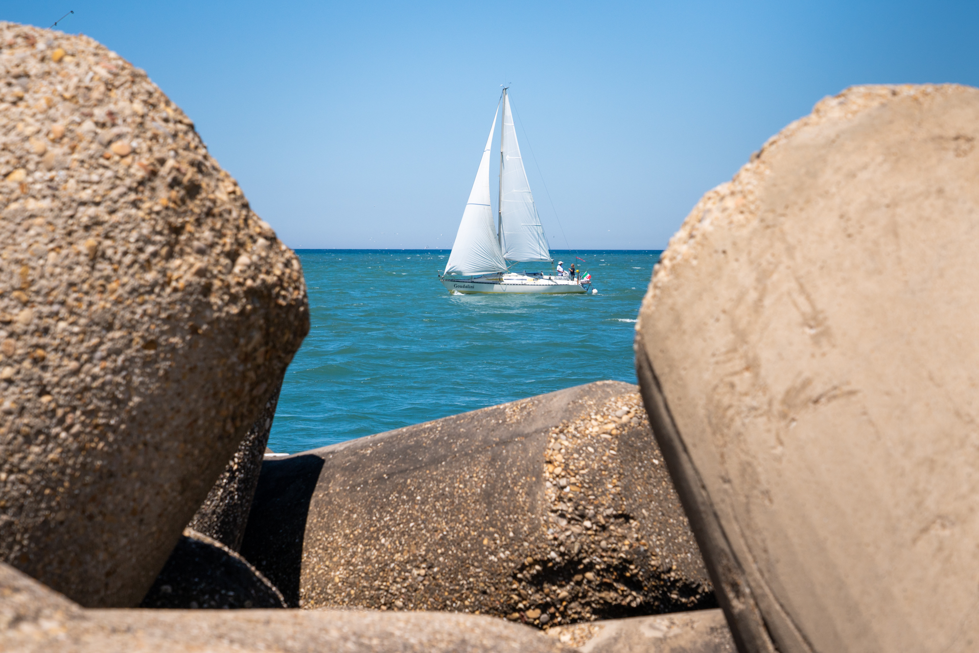  Patrizia Pilloni (in blue) and her sailing instructor, Claudio Rinaldini (in white), sail a boat into open waters from Fiumicino Harbor in Italy. 