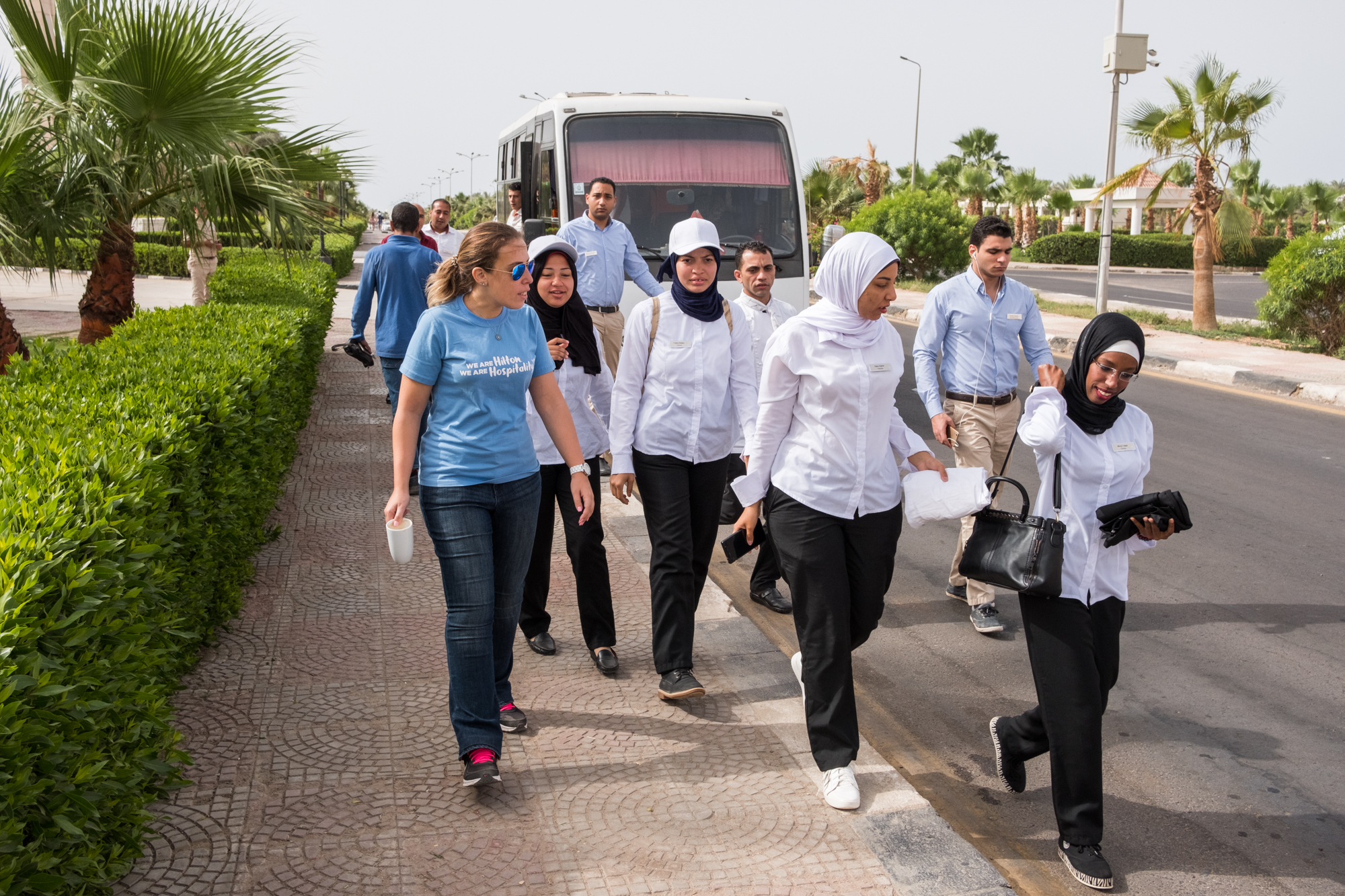  Ingy (left) greets several of the training program participants as they arrive by bus to start work. 