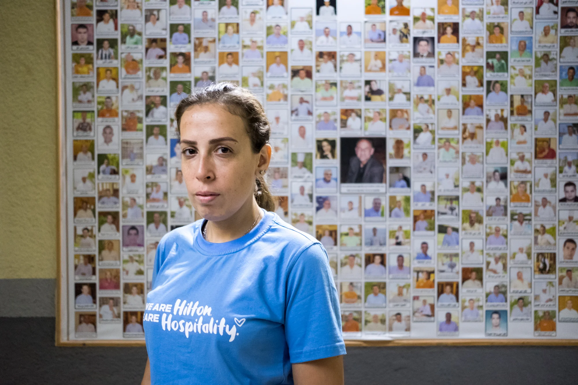 Ingy Helal, a Hilton Team Member and Thrive Sabbatical winner, poses for a portrait on the grounds at Hilton Sharm Waterfalls Resort in Sharm El Sheikh, Egypt. Ingy introduced a training program at the property to help young adults, especially women, enter the tourism and hospitality industry. On the wall is the current staff photo collection, which is predominantly men; Ingy’s training program will introduce more women into the workforce.
