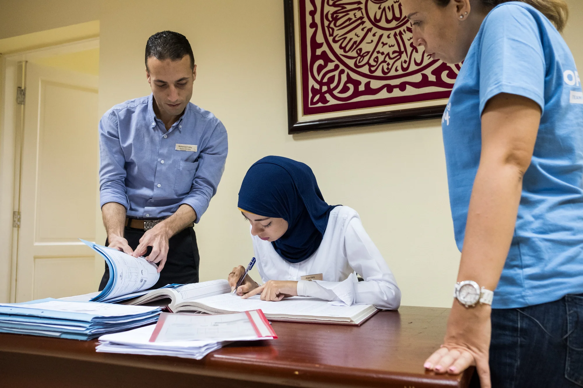 Arwa (center), a trainee in the Human Resources Department at Hilton Sharm Waterfalls Resort in Sharm El Sheikh, Egypt, prepares employee paperwork with the help of her boss (left). Ingy Helal (right), the Hilton Team Member who introduced the program, looks on.