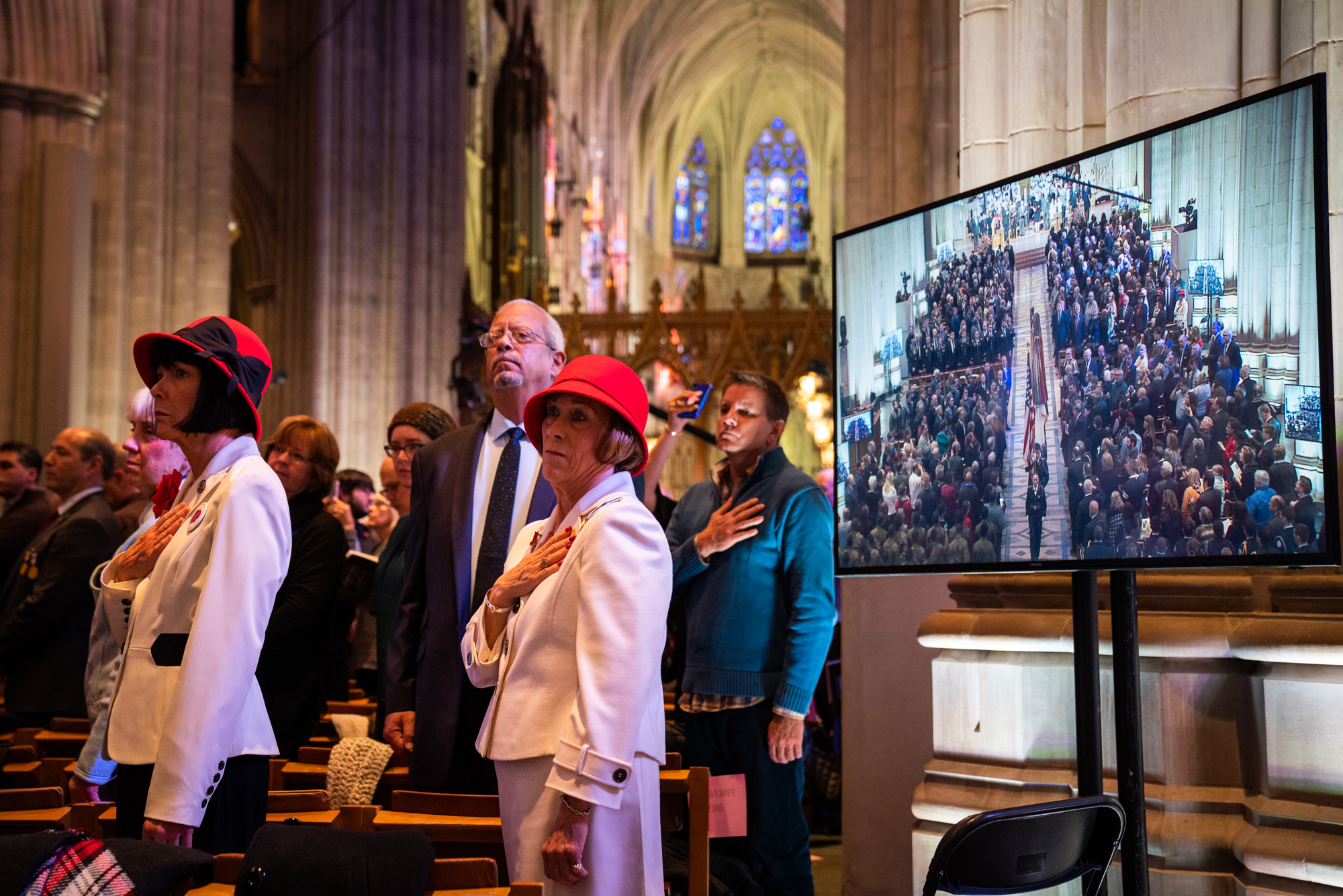  Attendees stand and acknowledge The National Anthem as the final procession passes through the cathedral. 